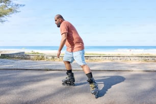 a man riding a skateboard down a street next to the ocean