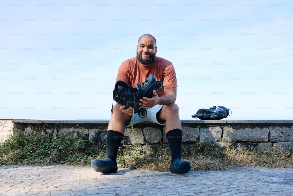 a man sitting on a stone wall holding a camera