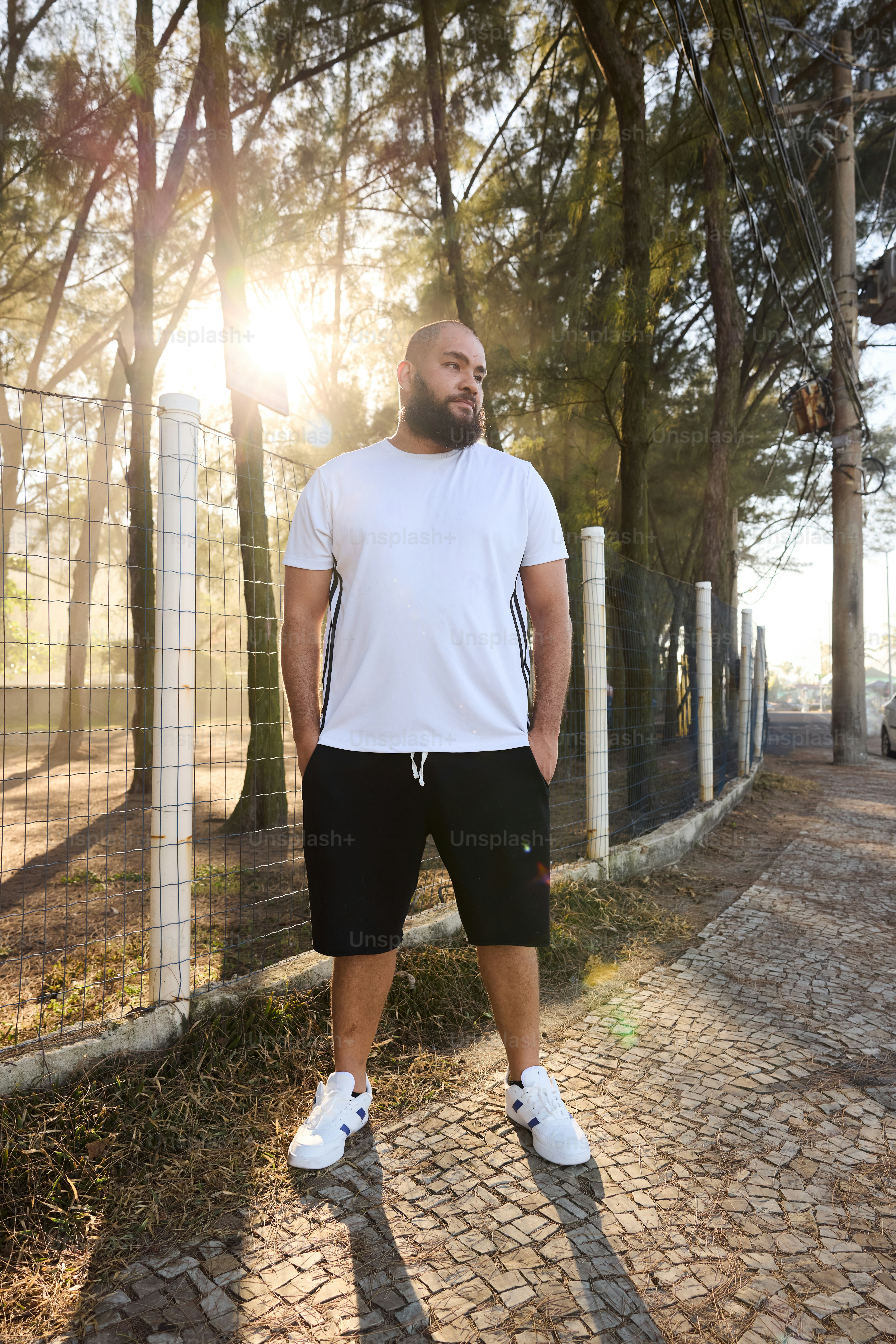 a man standing in front of a fence