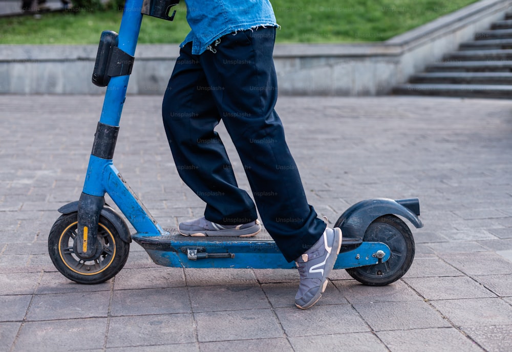 a person riding a scooter on a sidewalk