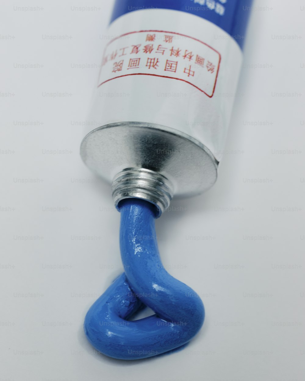 a blue tube with a blue handle on a white surface