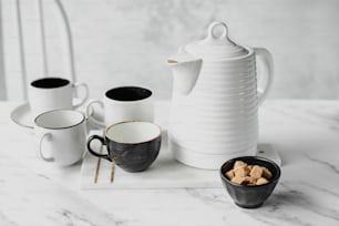 uma mesa coberta com xícaras de café e um bule de chá