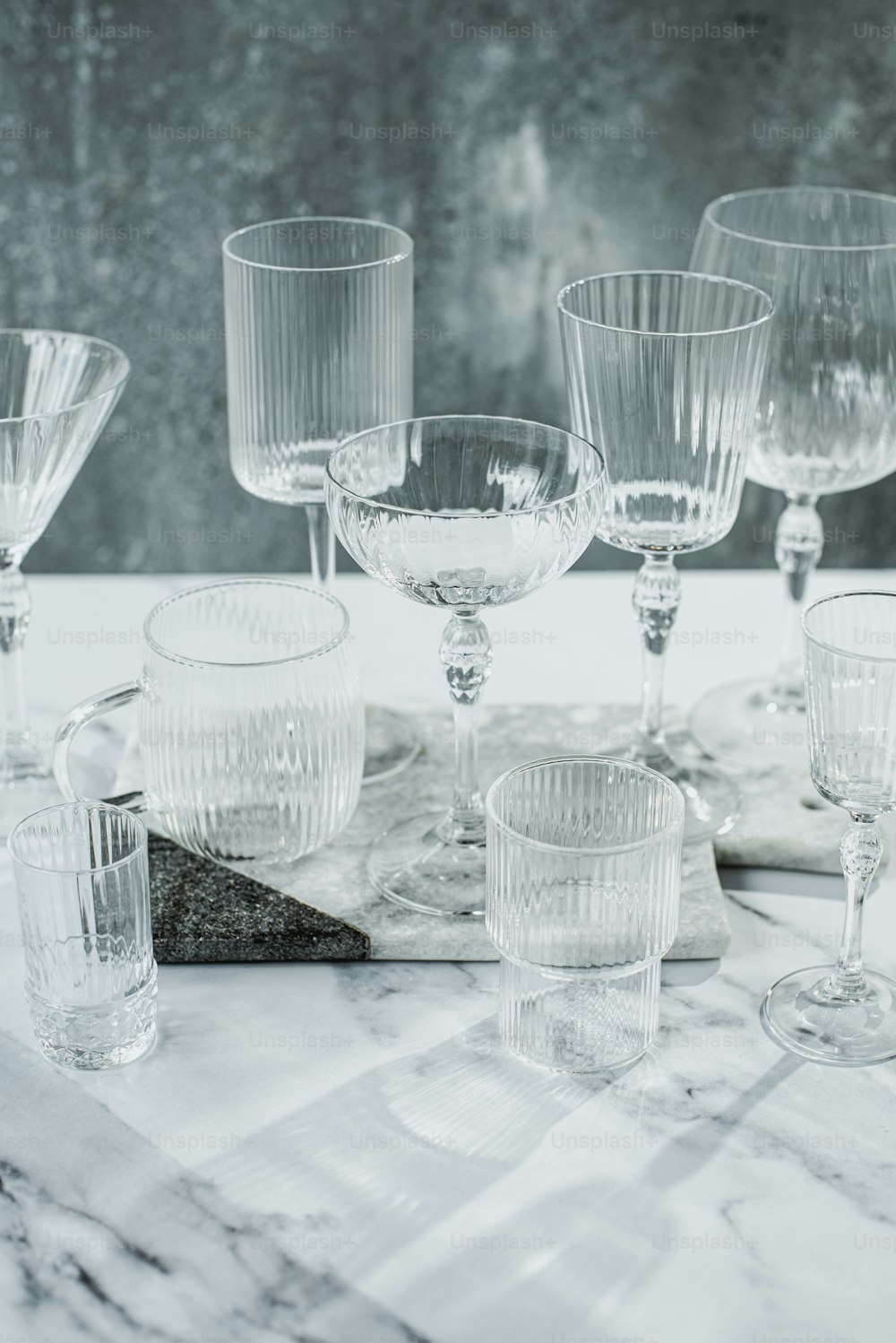 a table topped with lots of glasses on top of a table