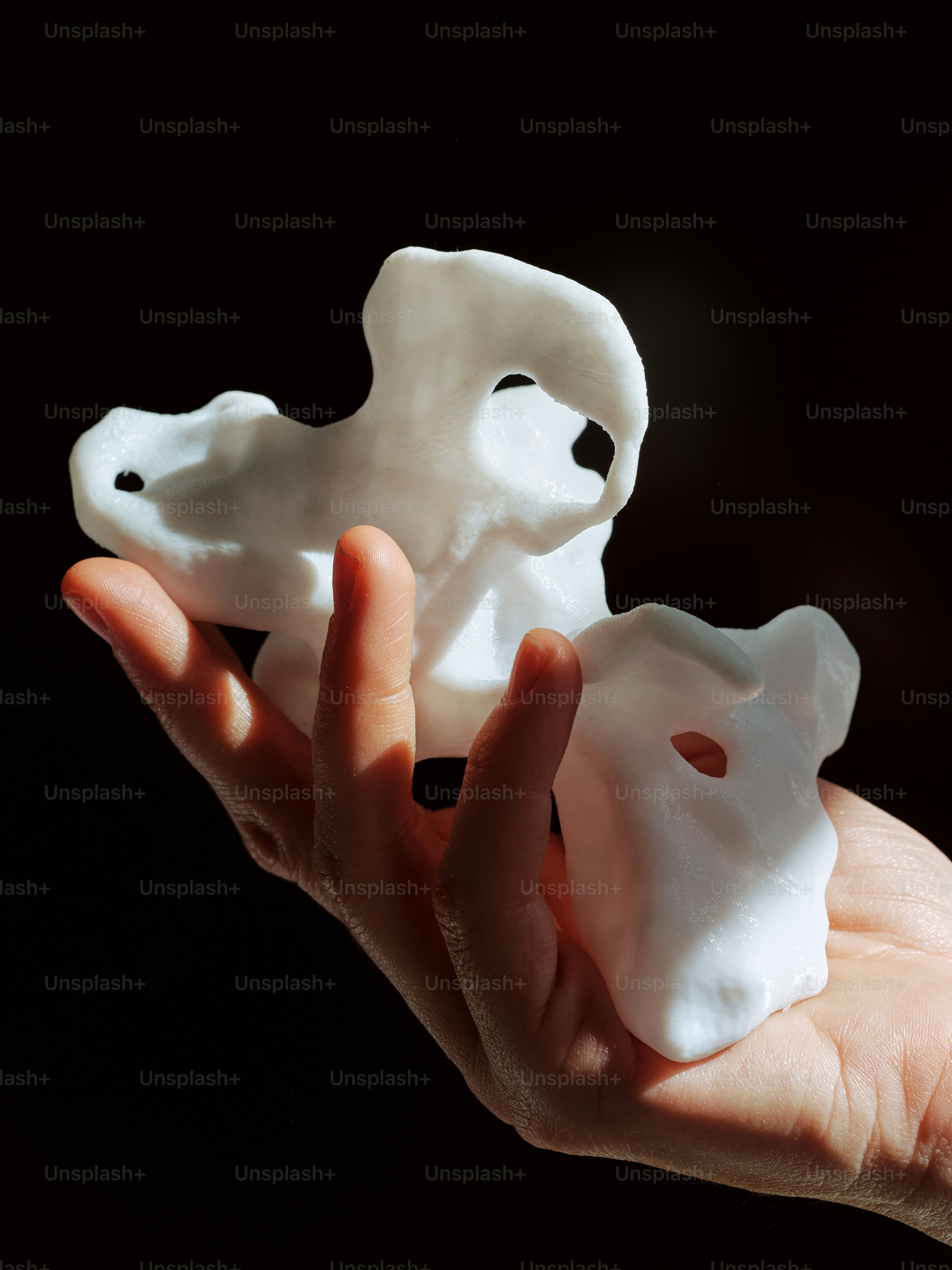 a hand holding a small white object in it's palm