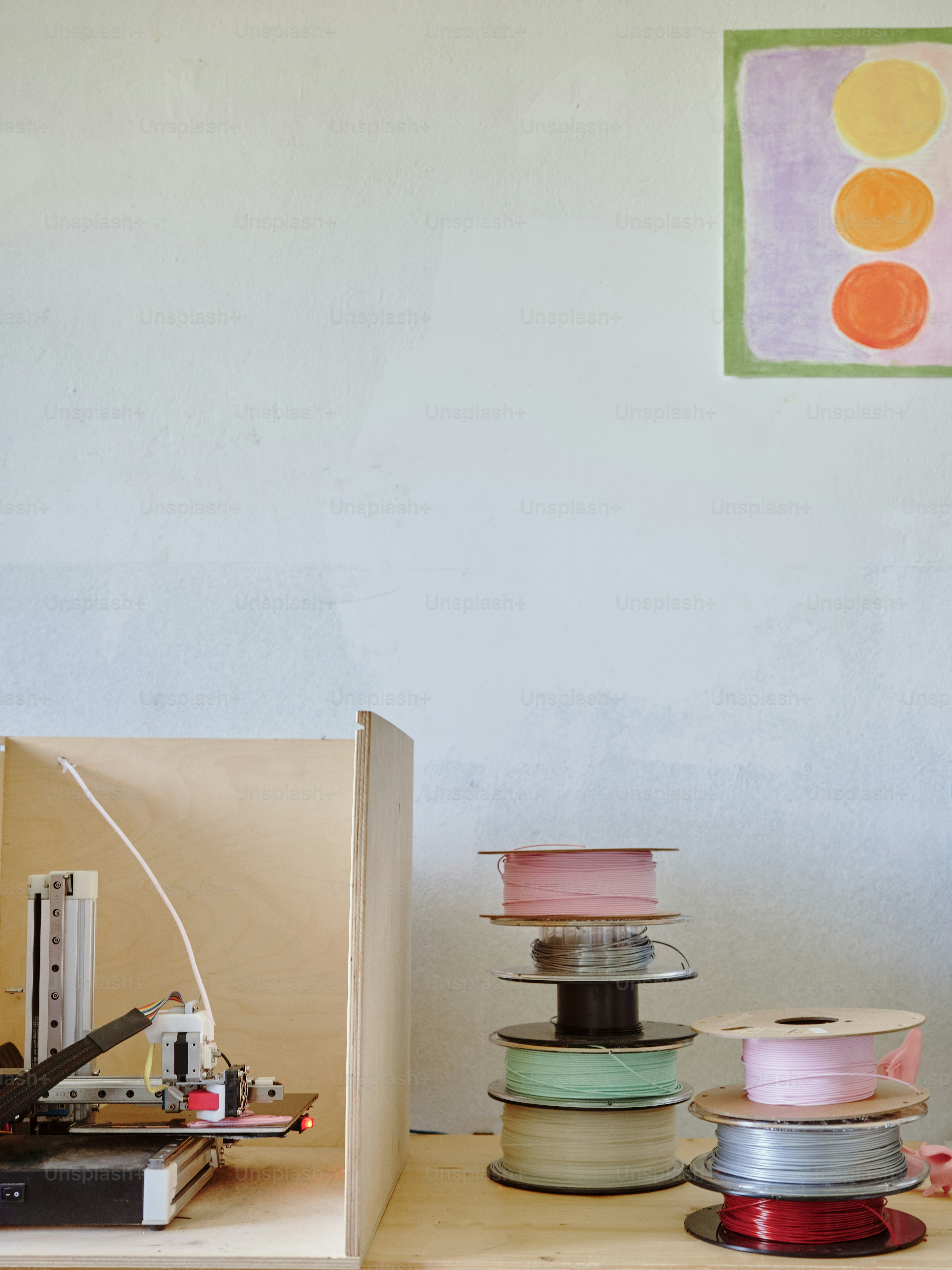 a wooden table topped with lots of spools of thread
