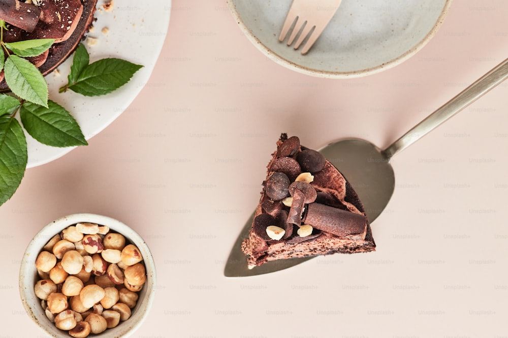 a piece of chocolate cake next to a bowl of nuts