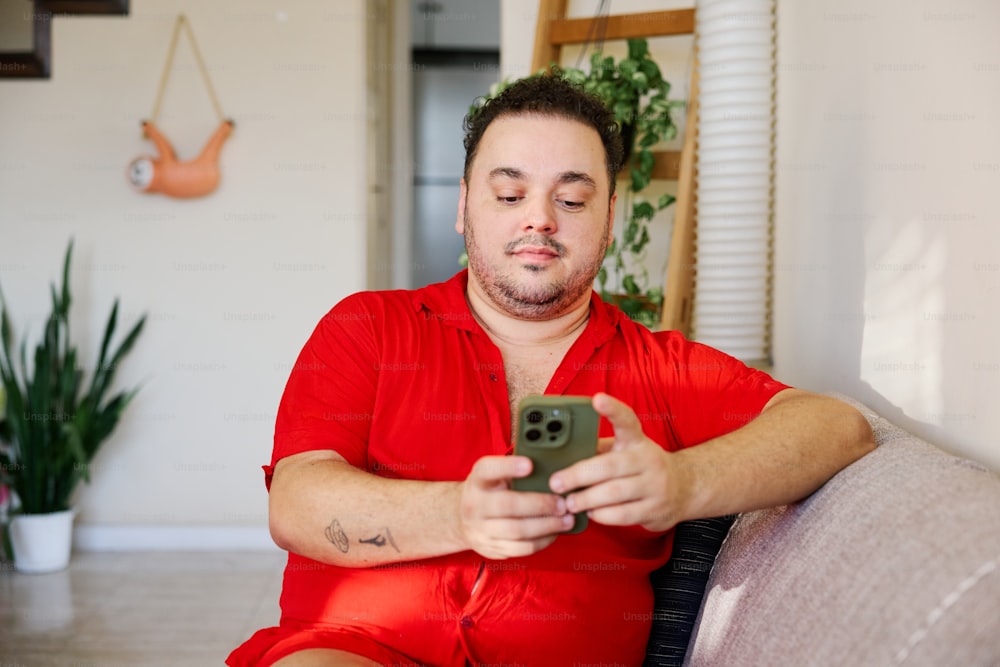 a man sitting on a couch holding a cell phone