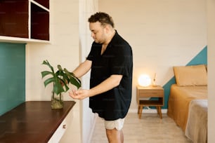 a man standing next to a shelf with a plant in it