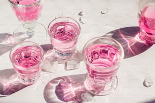 ピンク色の液体で満たされたグラスが置かれたテーブル