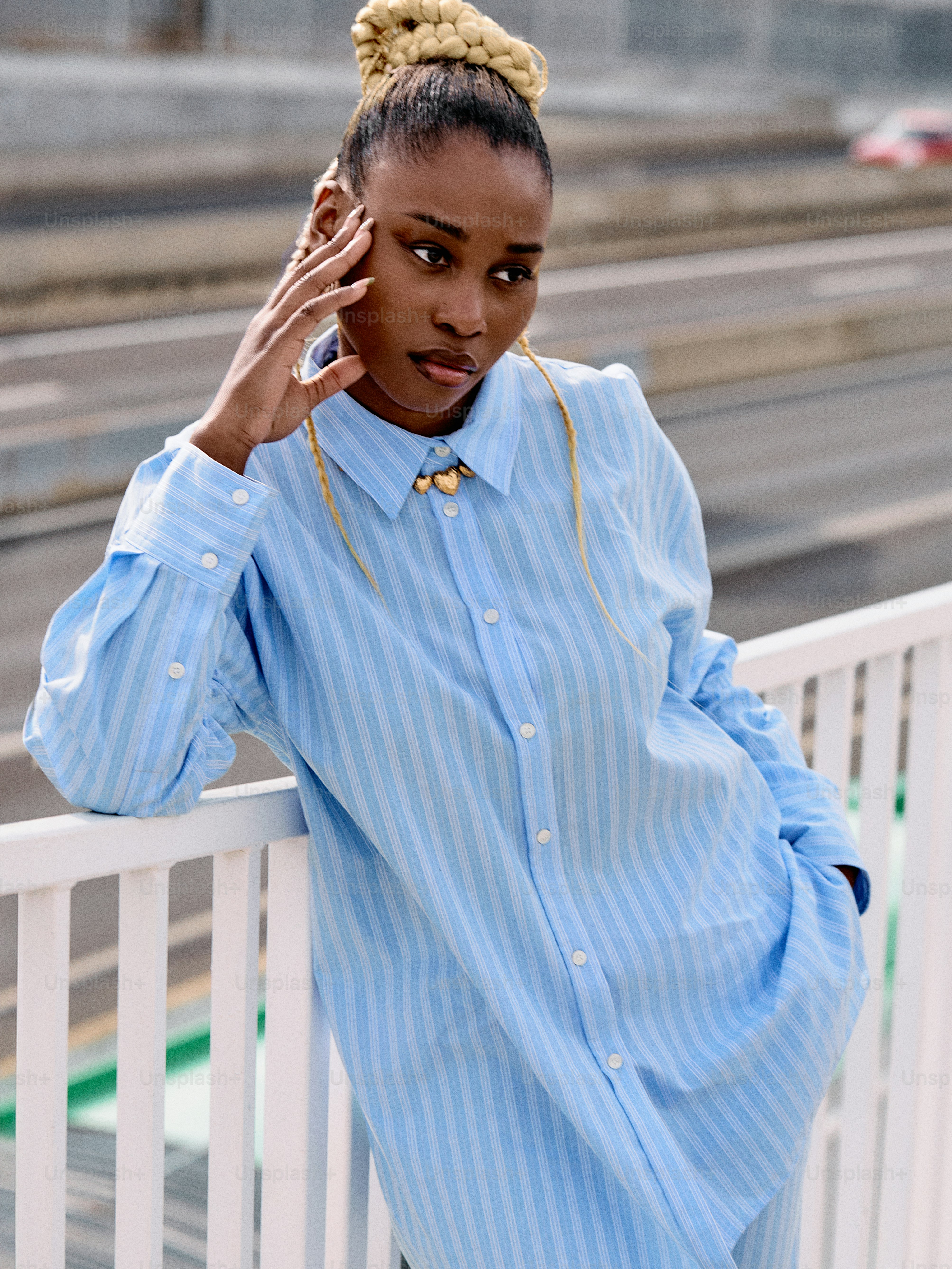 a woman in a blue shirt leaning against a white rail