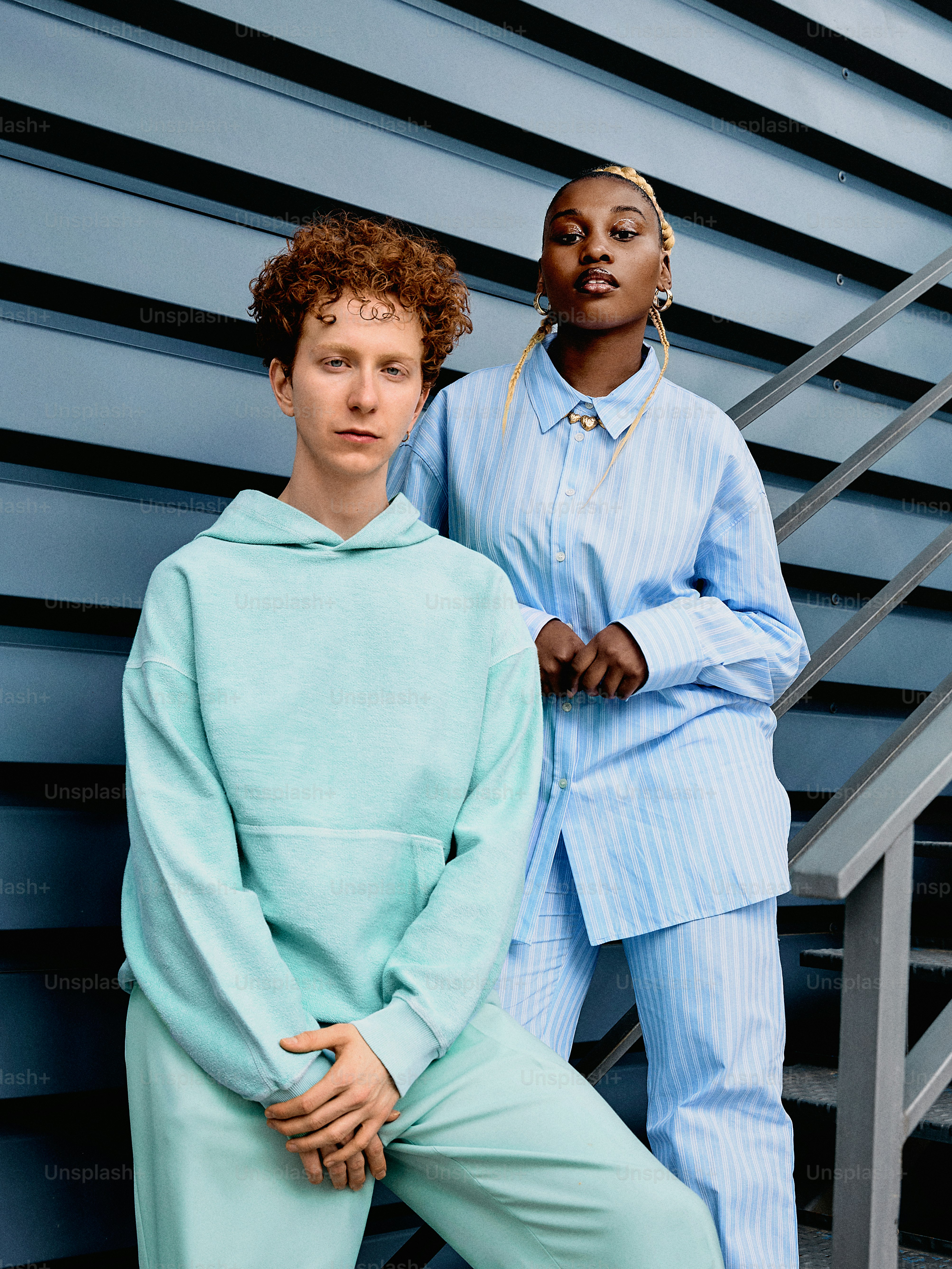 two people standing next to each other in front of a building