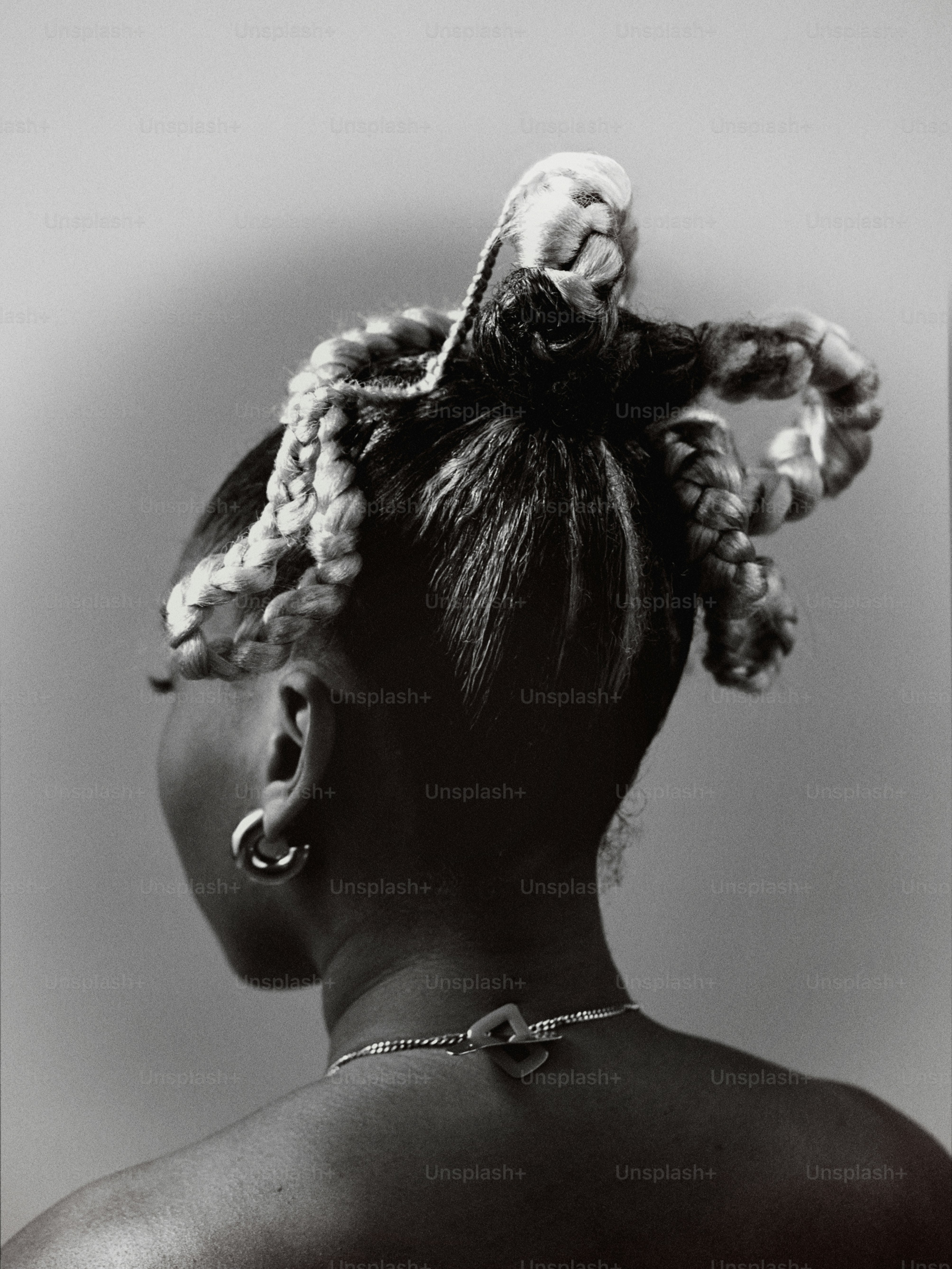 uma foto em preto e branco de uma mulher com tranças no cabelo