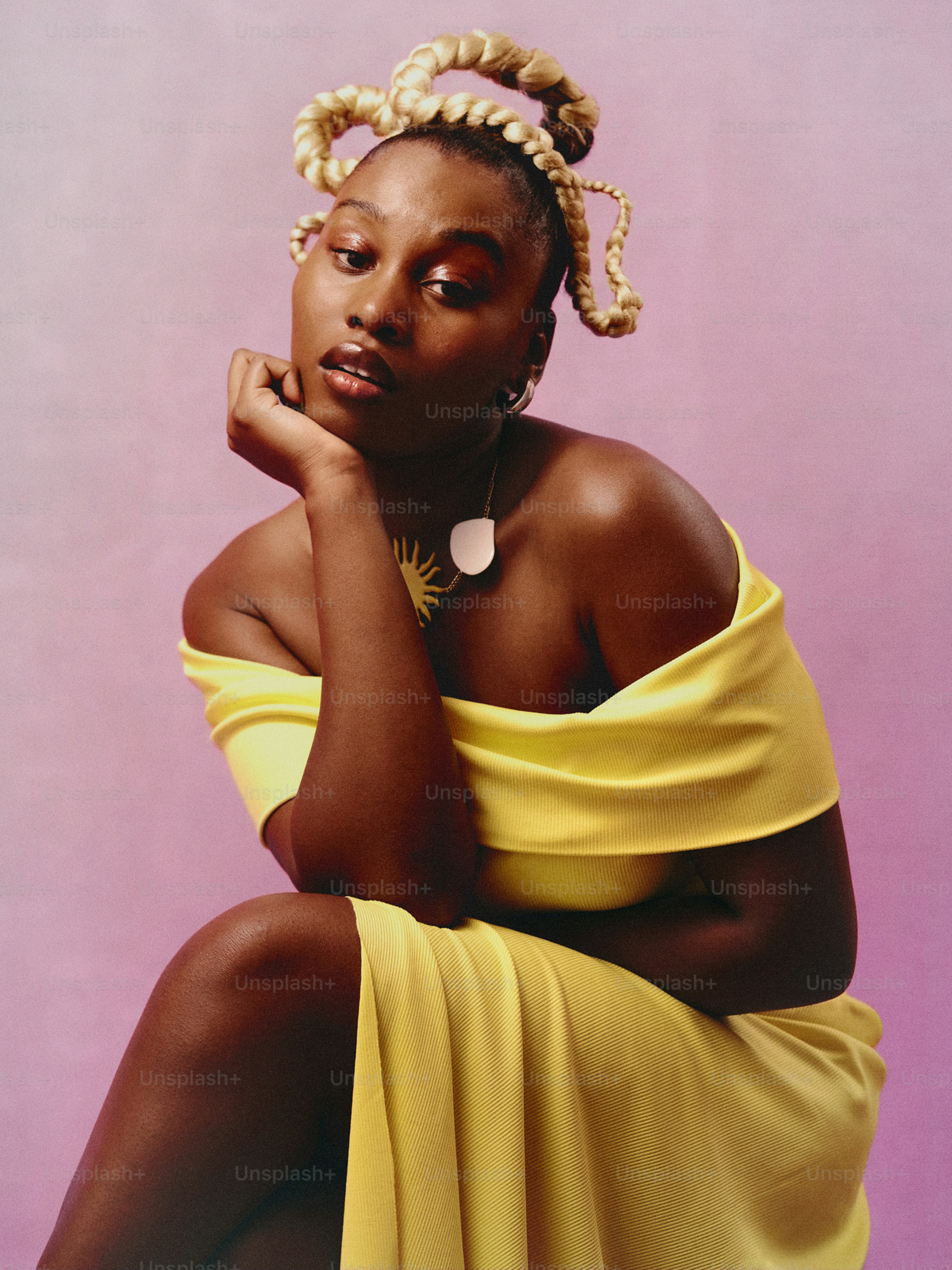 a woman in a yellow dress sitting on a stool
