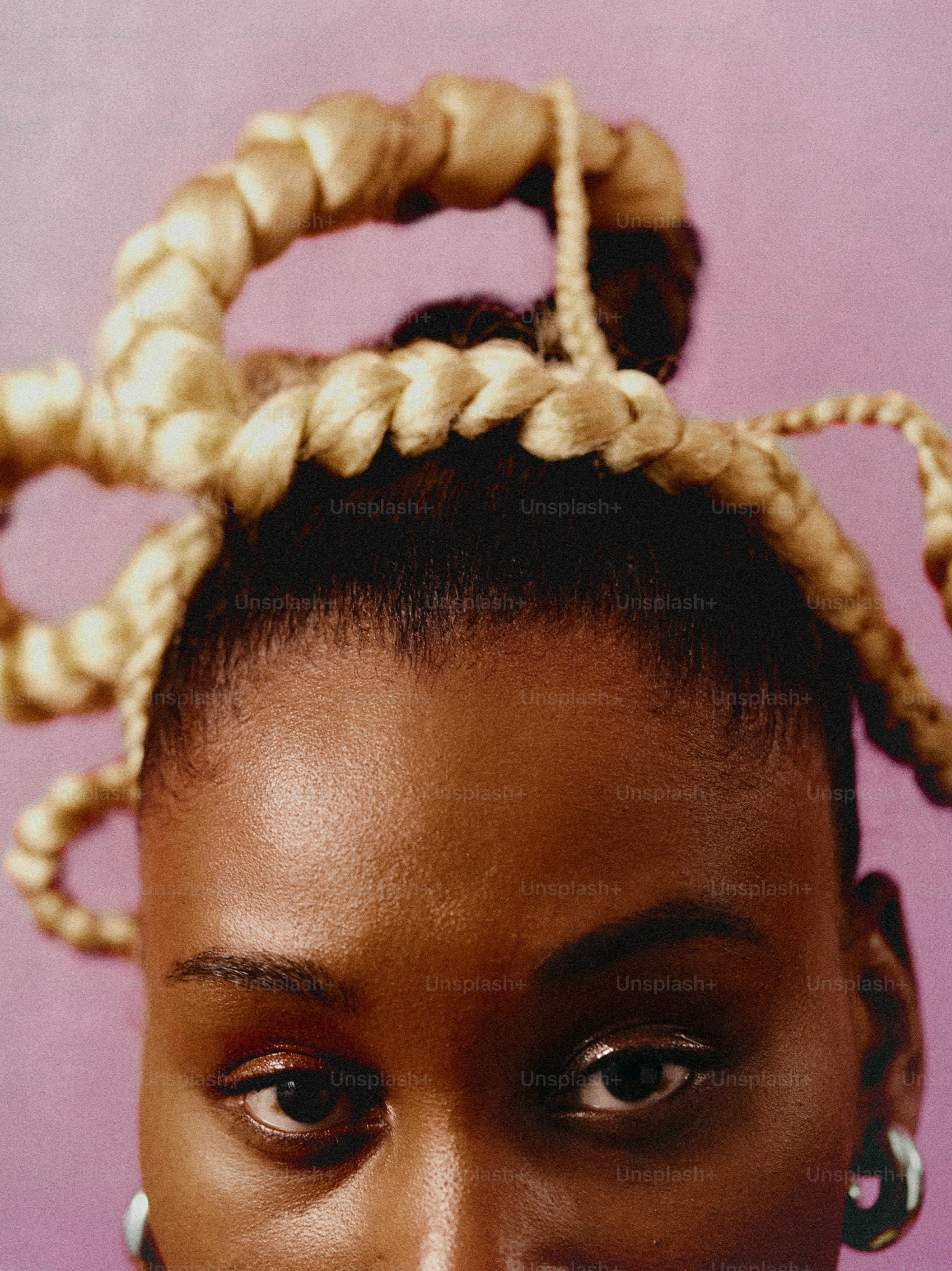 a woman with braids on her head looking at the camera