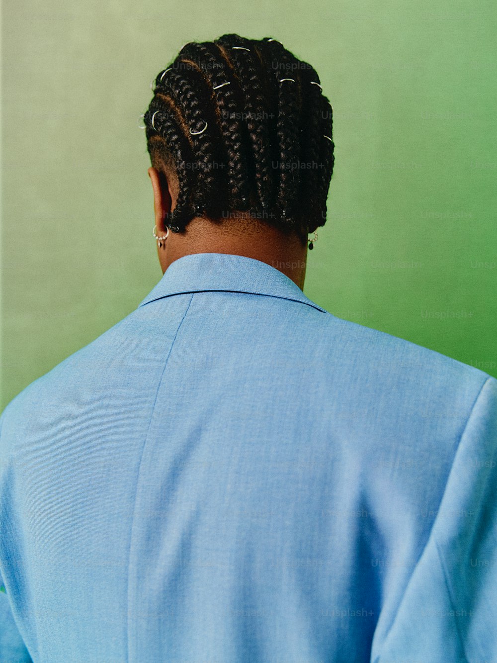 a man with a blue shirt and a pair of braids in his hair