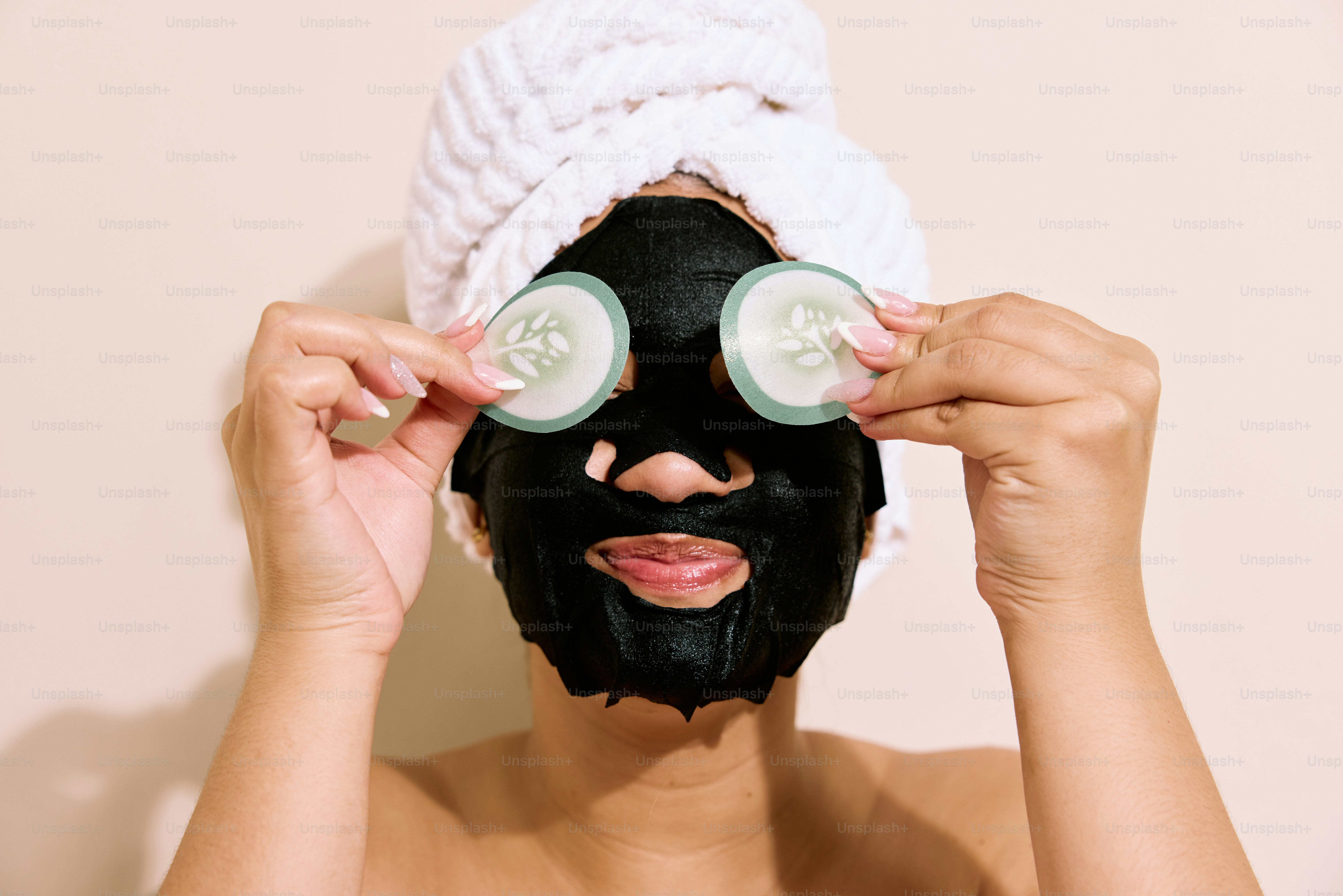 a woman with a towel on her head and a black mask on her face