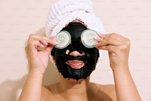 una donna con un asciugamano in testa e una maschera nera sul viso