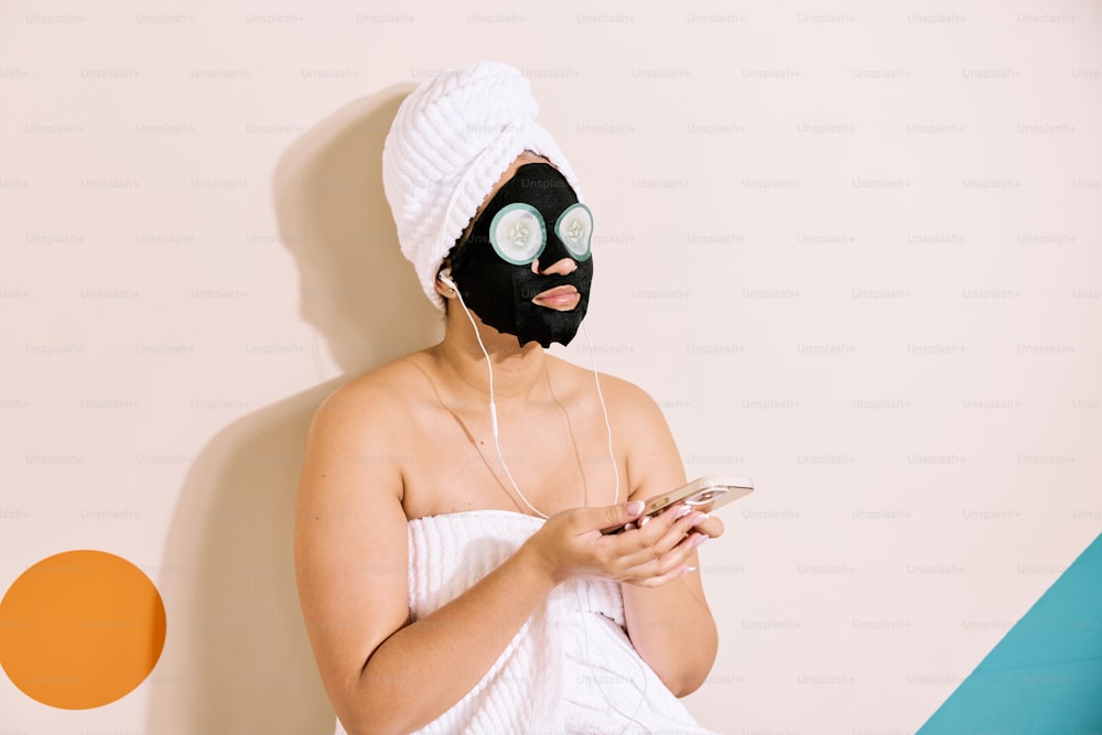 a woman wearing a black mask and a white towel on her head