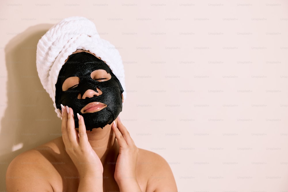 a woman with a towel on her head and a black mask on her face