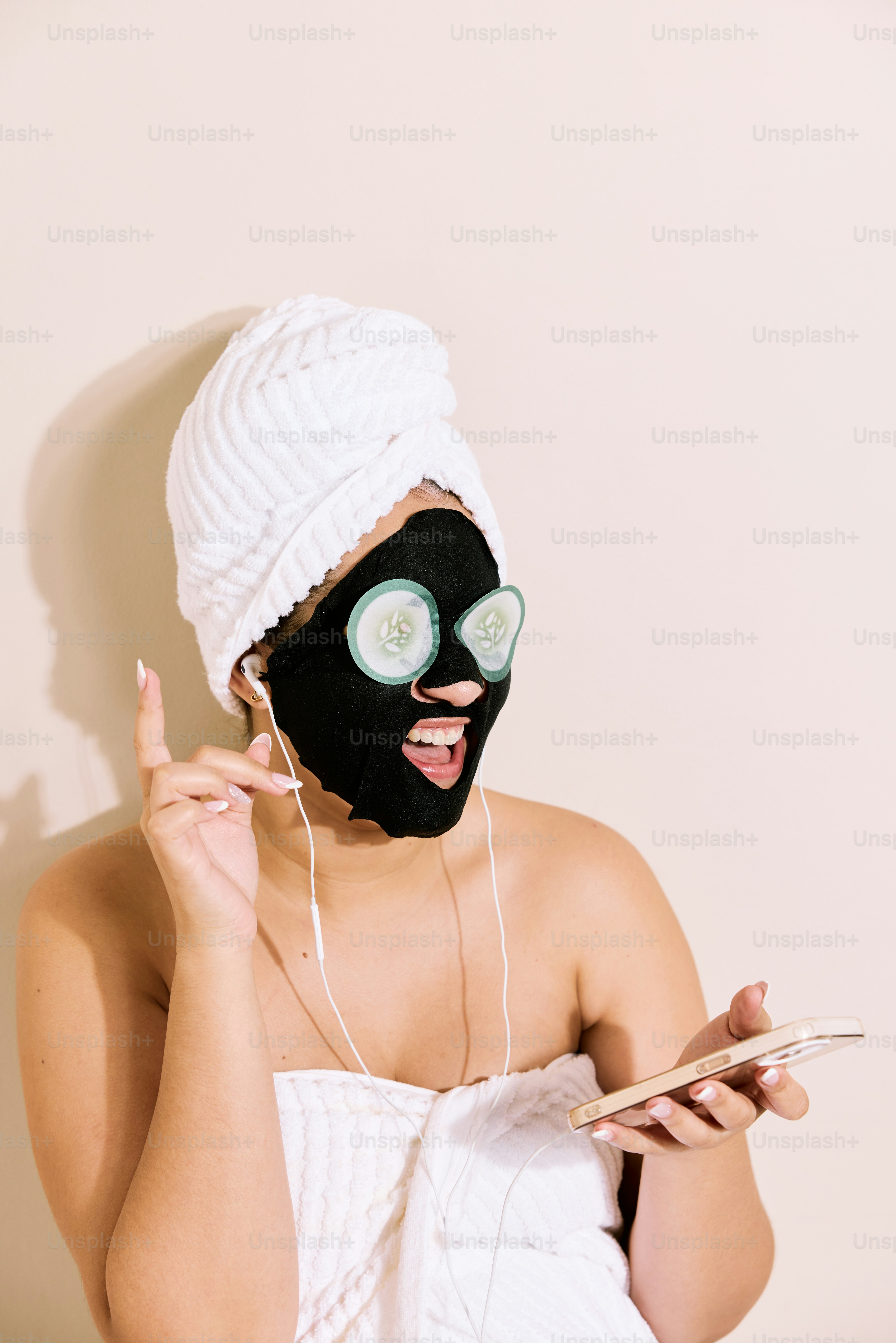 a woman wearing a black mask holding a cell phone