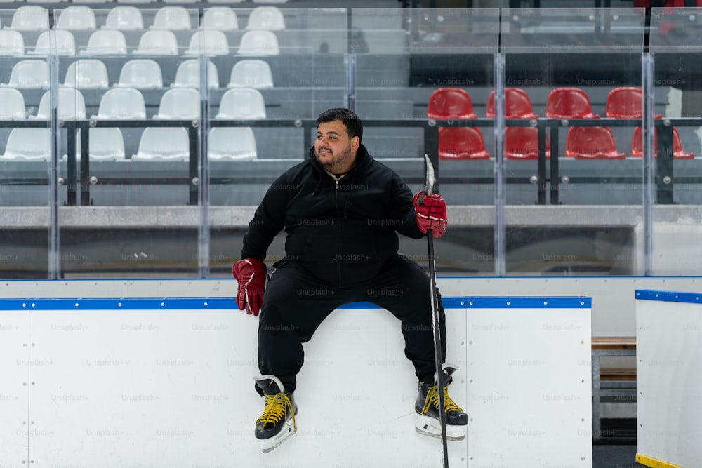 a man sitting on top of a ice rink