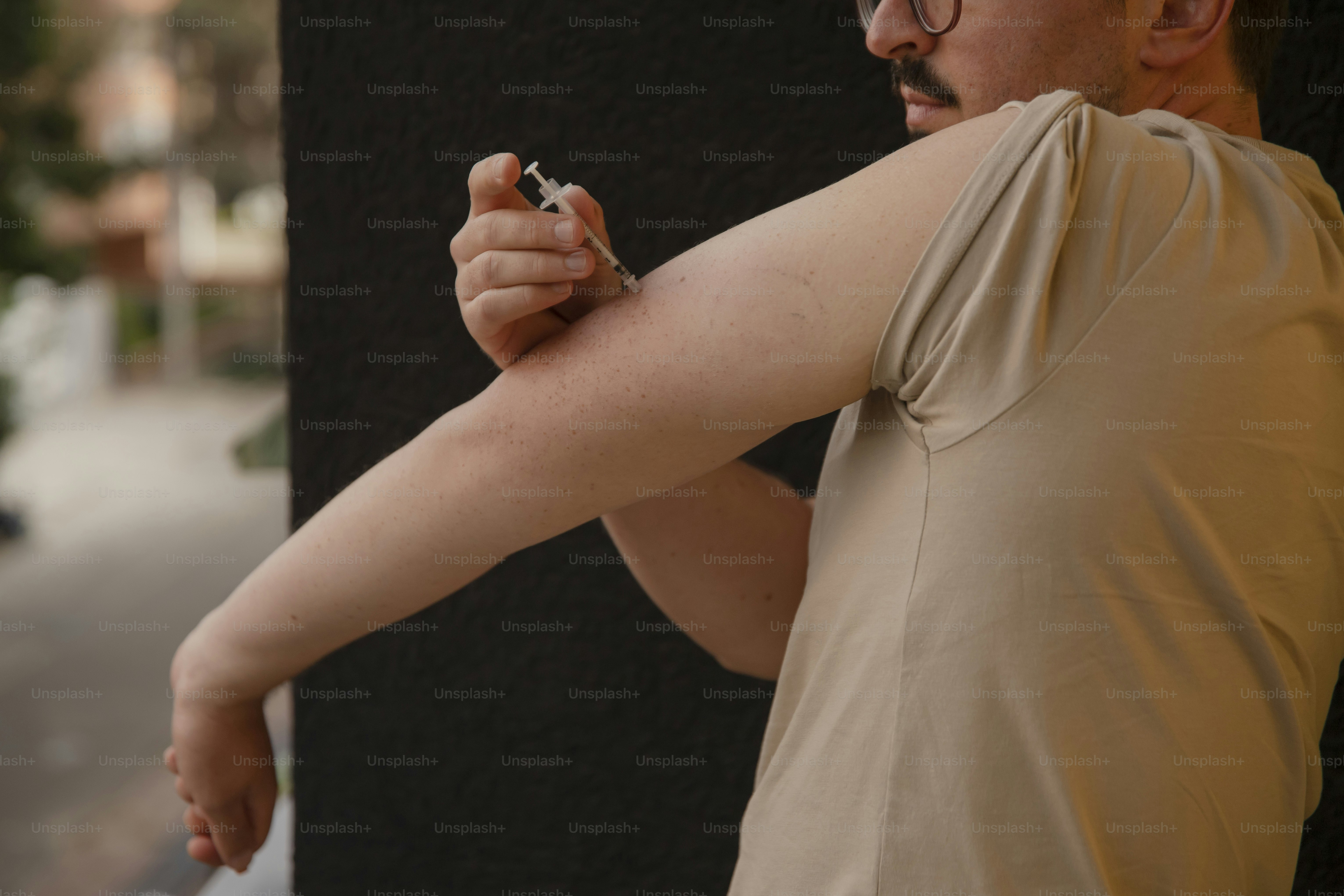 Ein Mann mit Schnurrbart und Brille hält eine Zigarette in der Hand