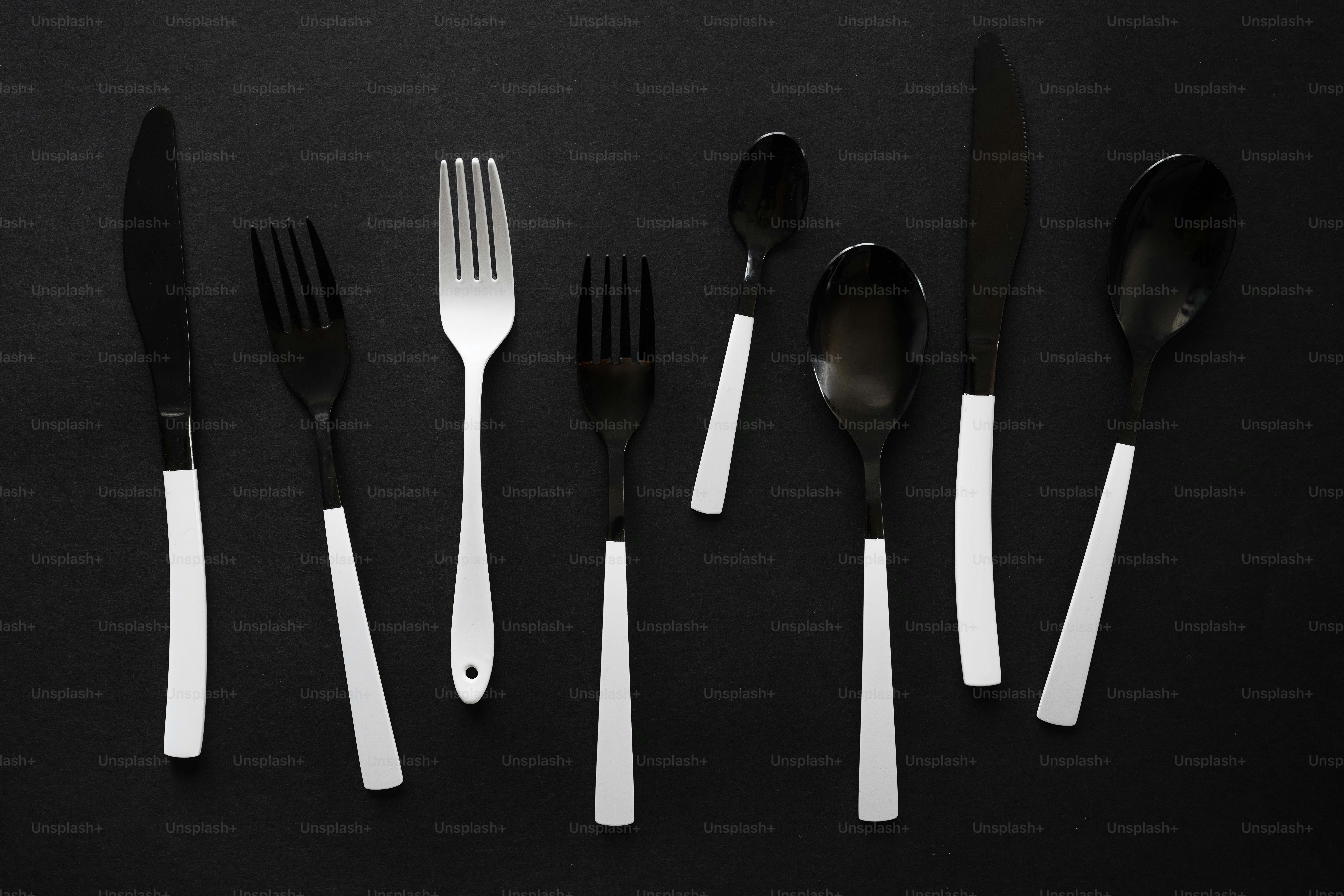 a group of forks and spoons sitting next to each other