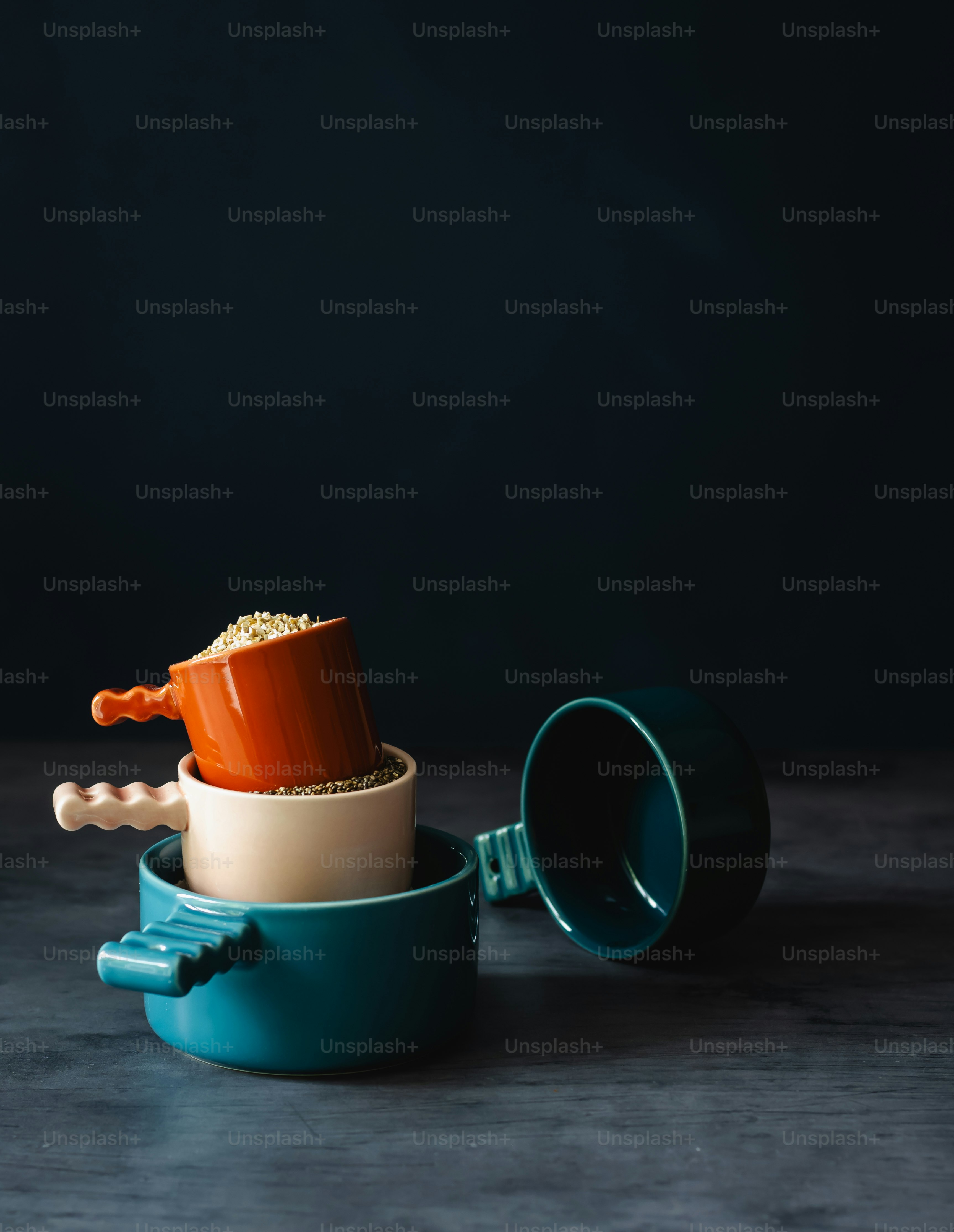 a blue cup with a red lid and a brown cup with a spoon in it