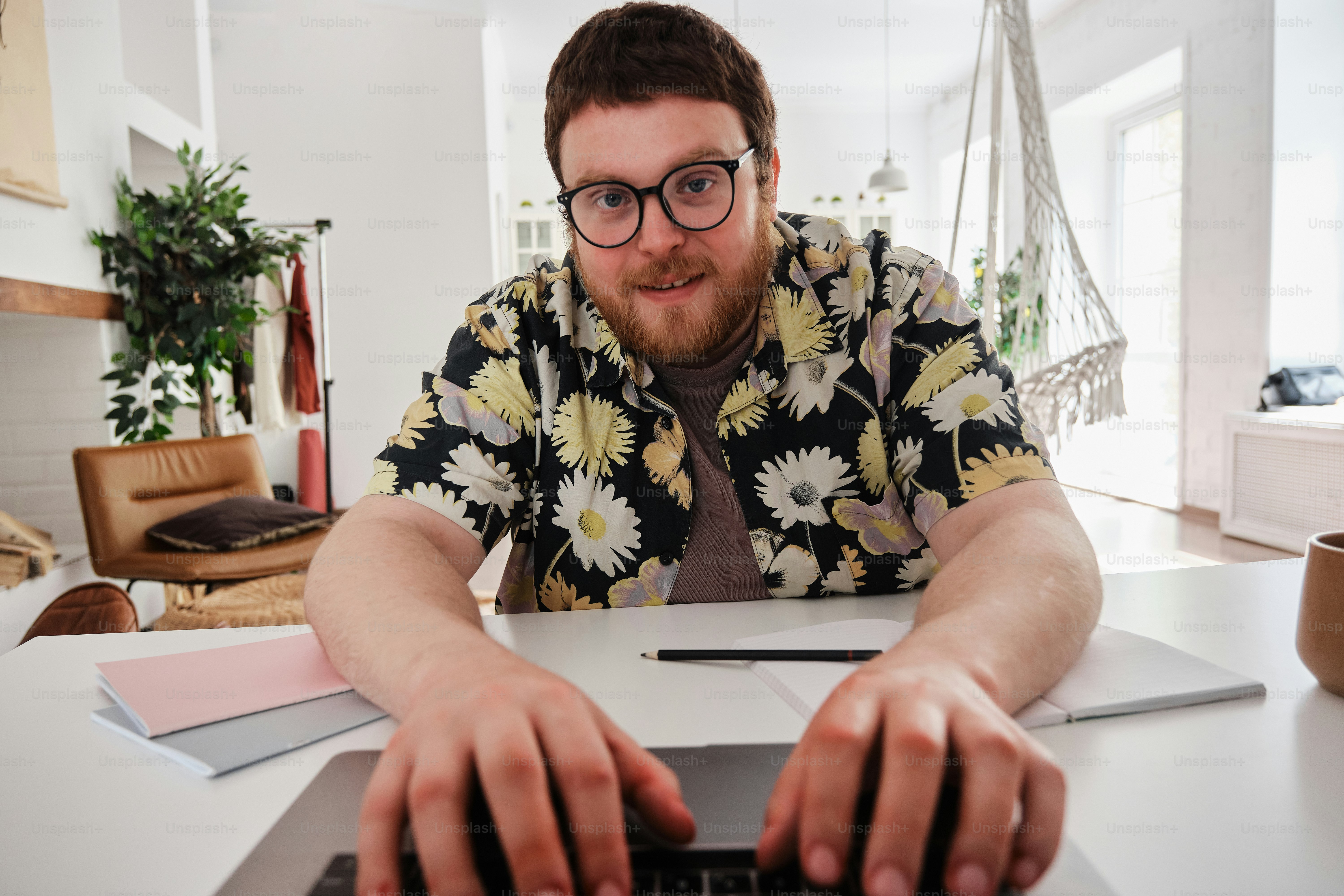 a man sitting at a table typing on a laptop