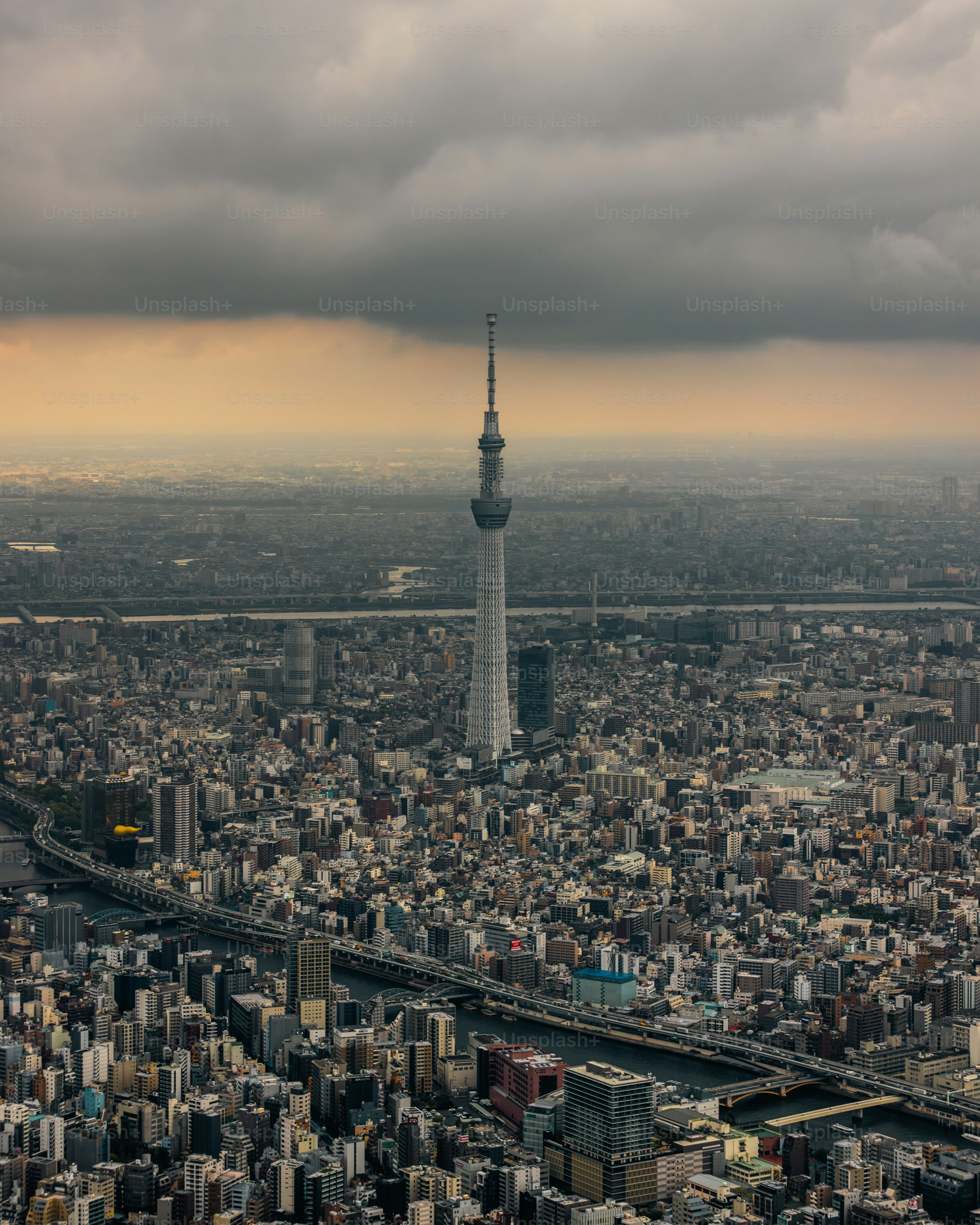 a very tall tower towering over a city under a cloudy sky