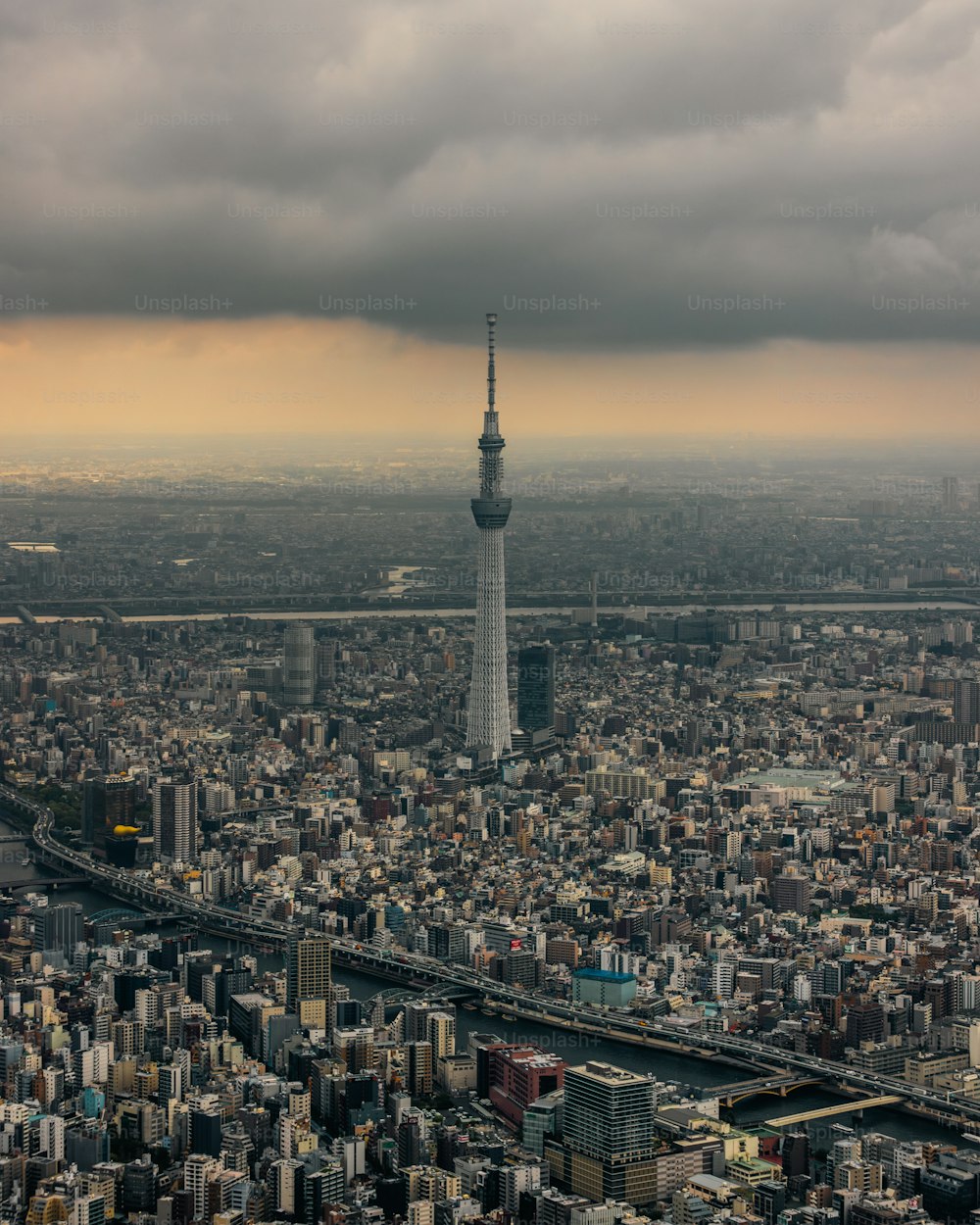 a very tall tower towering over a city under a cloudy sky