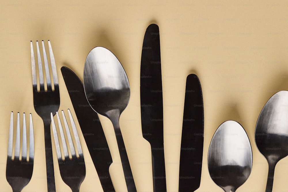 a group of forks and spoons sitting next to each other