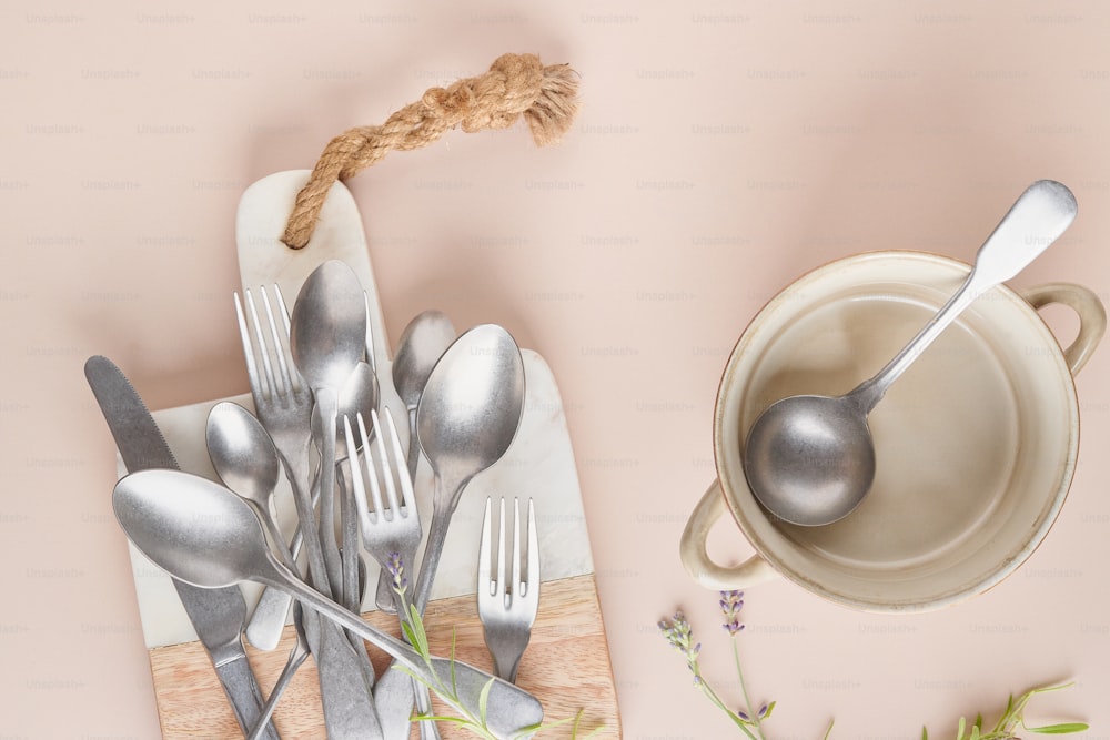spoons, forks, and a bowl on a table