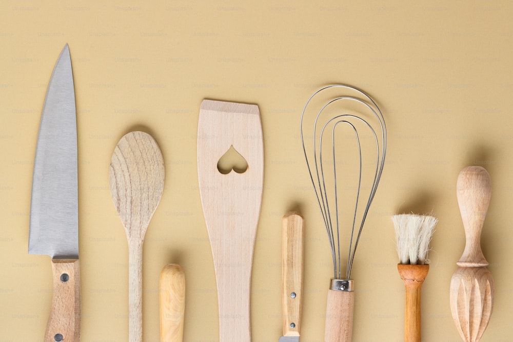 a variety of kitchen utensils lined up on a wall
