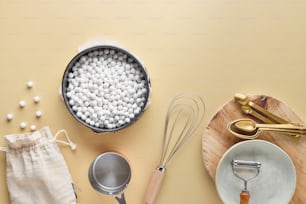 a table topped with a pan filled with white balls