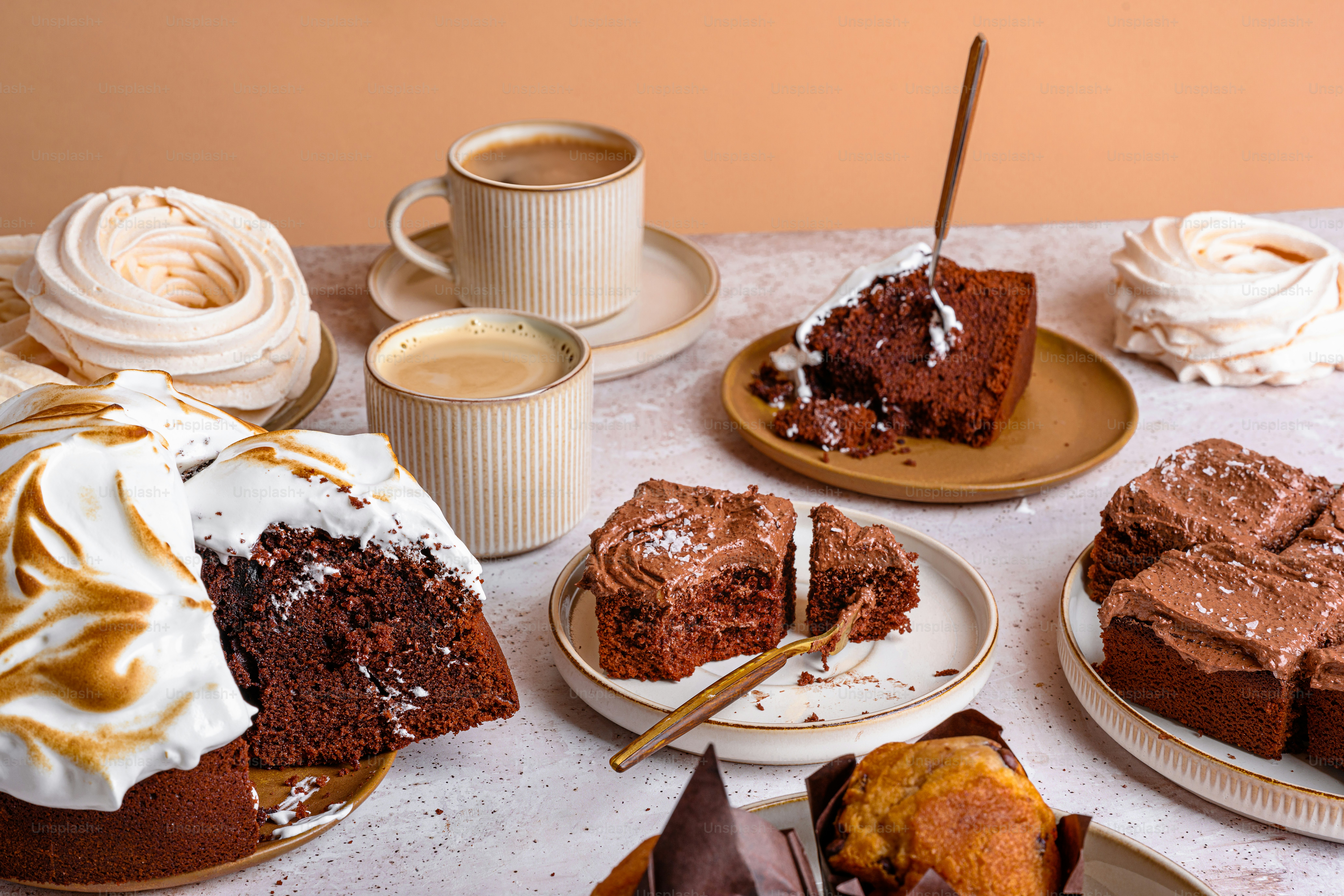 a table topped with lots of different types of cakes