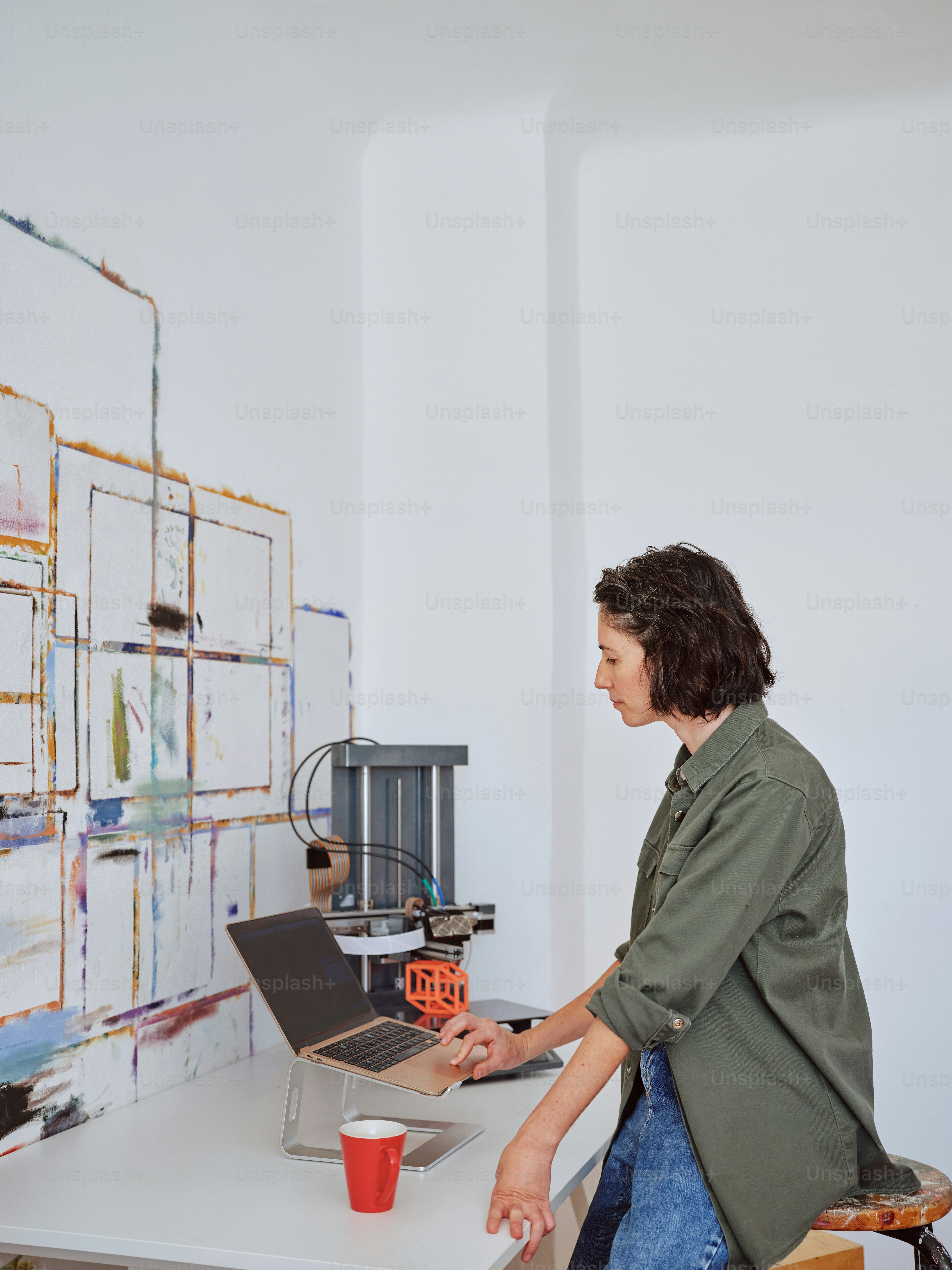 a woman sitting at a desk using a laptop computer