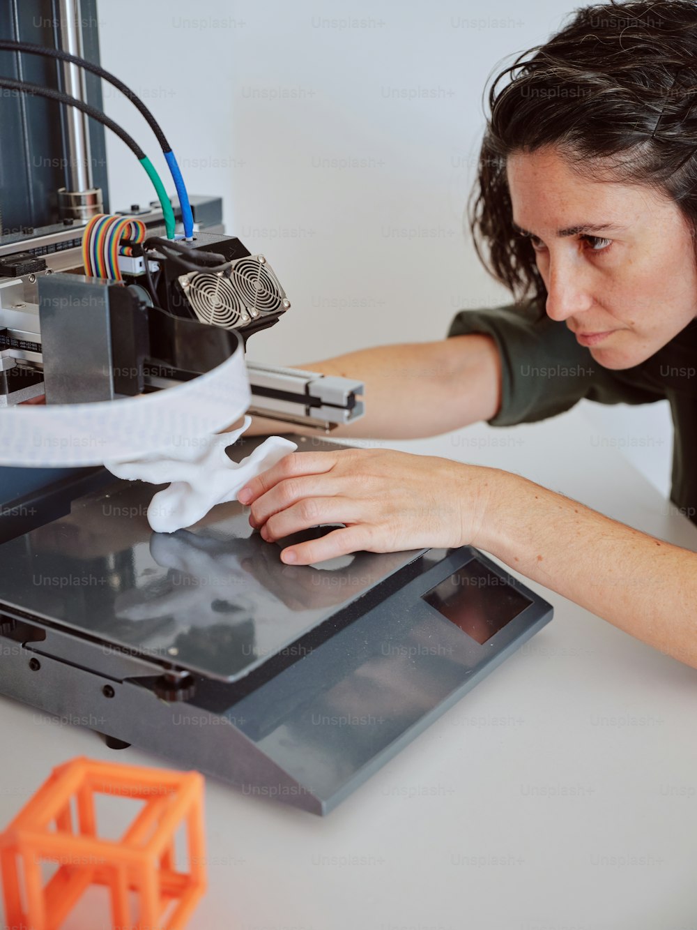 a woman is working on a 3d printer