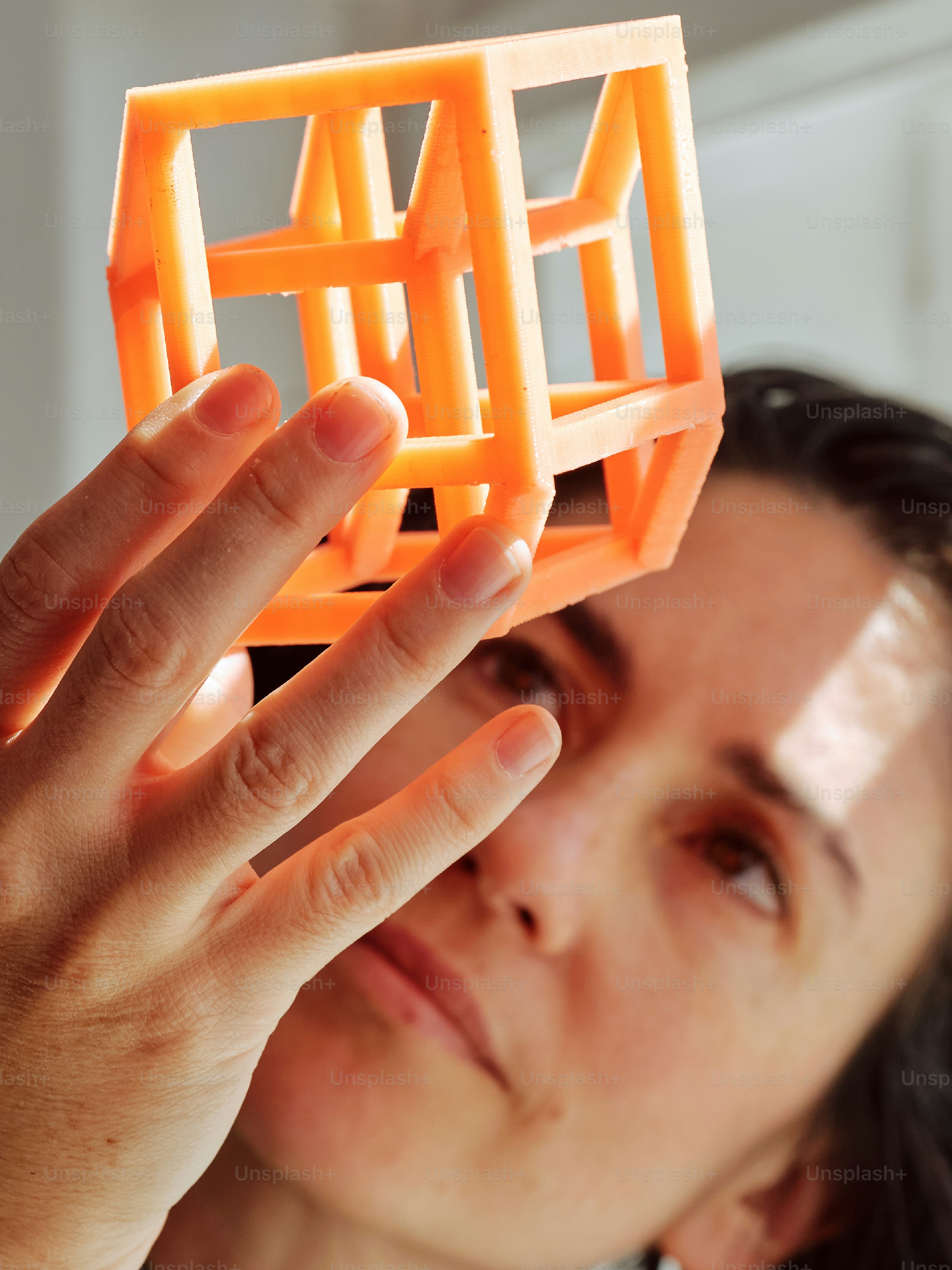 a woman holding up an orange object in front of her face