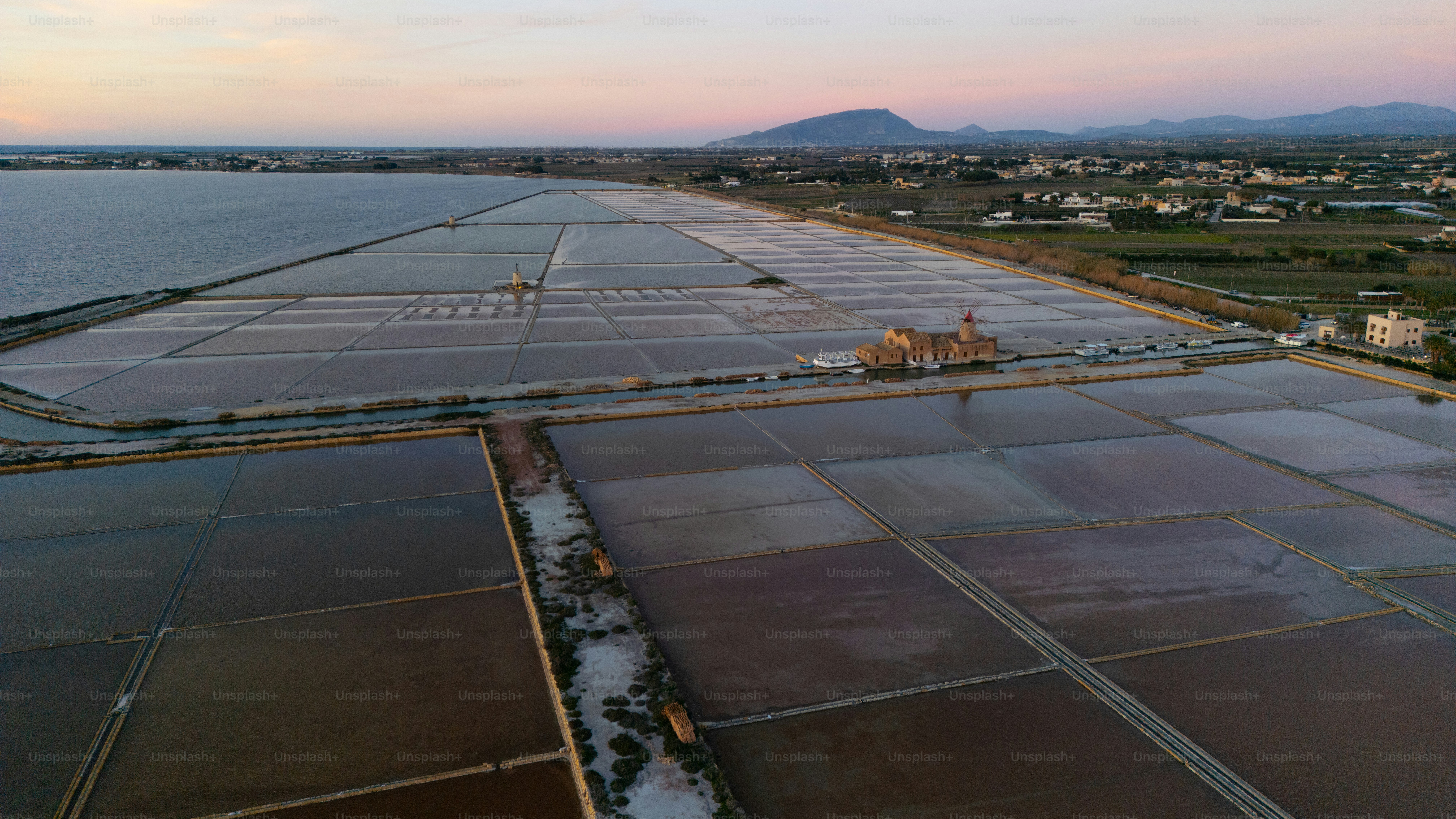 an aerial view of a large field next to a body of water
