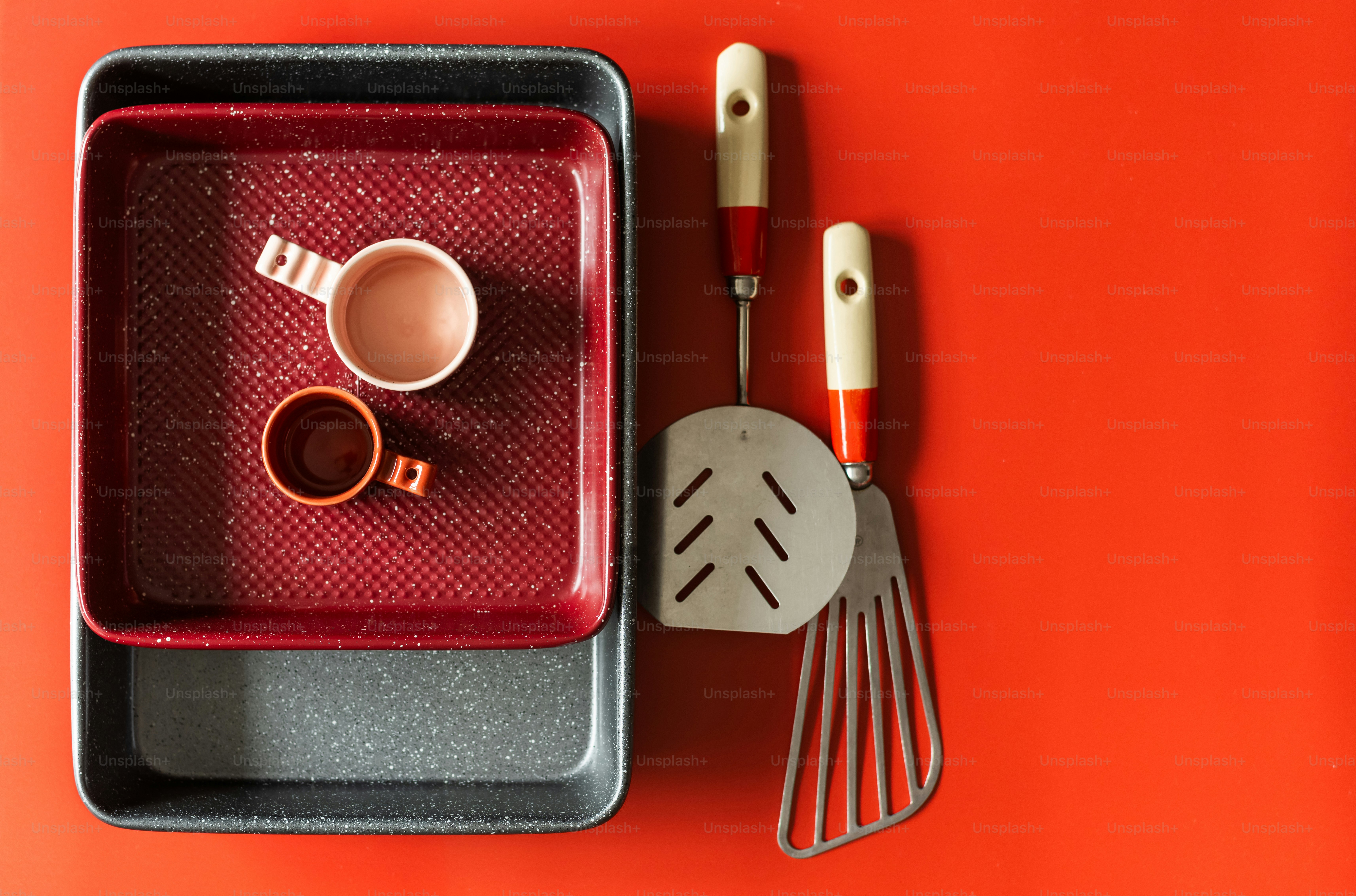 a red tray with utensils and a cup on it