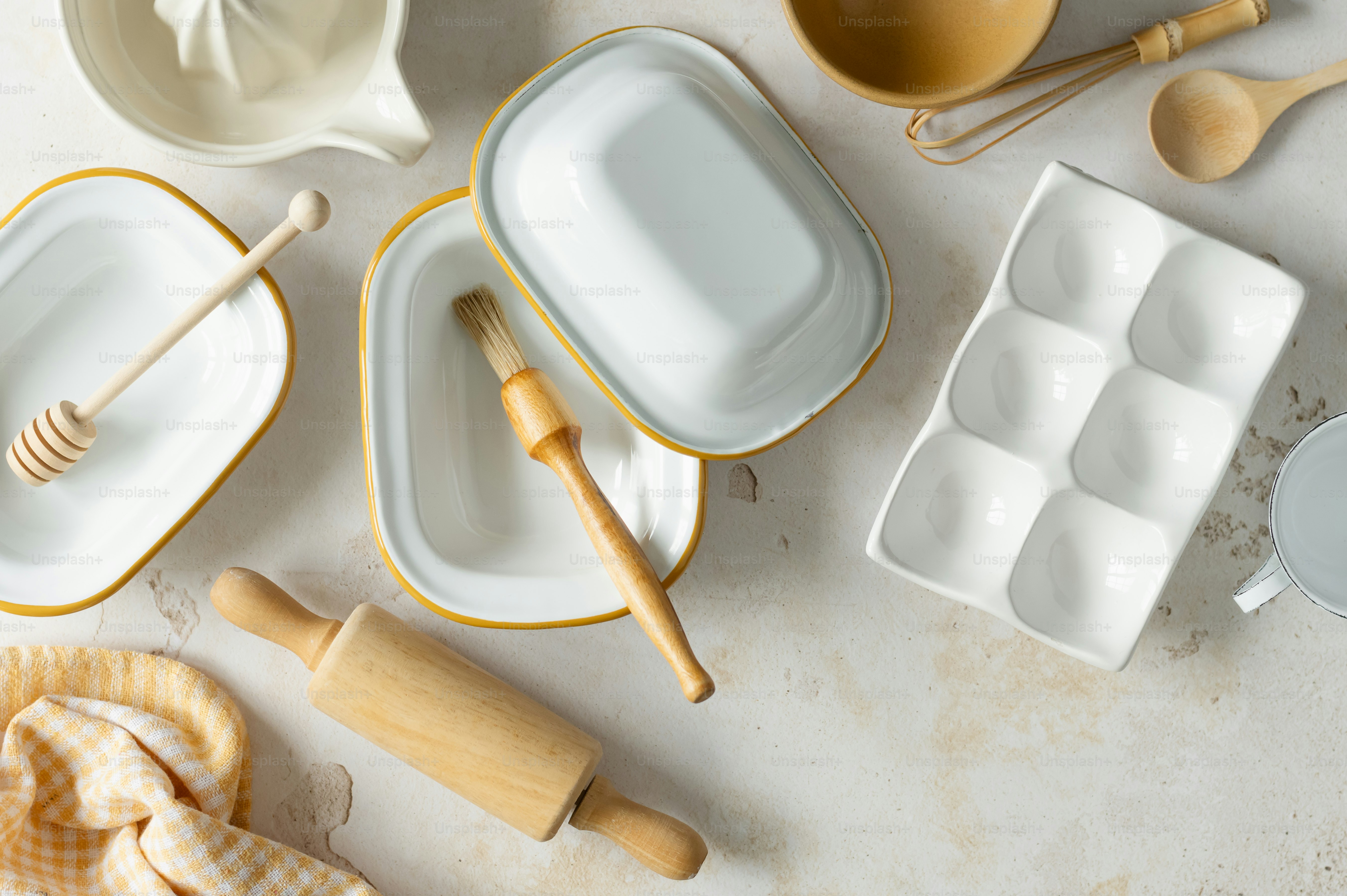 a table topped with white dishes and wooden utensils