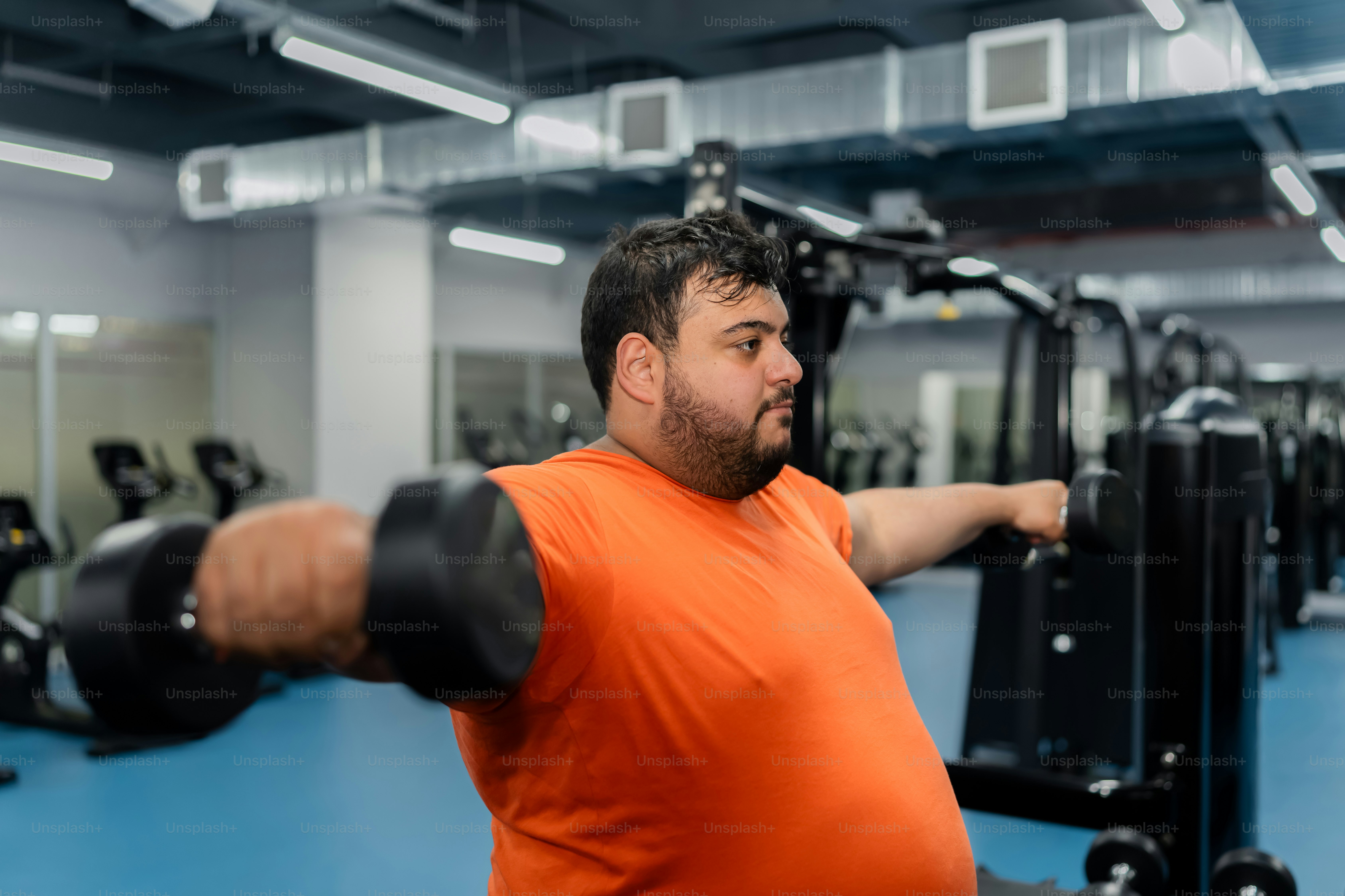 a man in an orange shirt in a gym