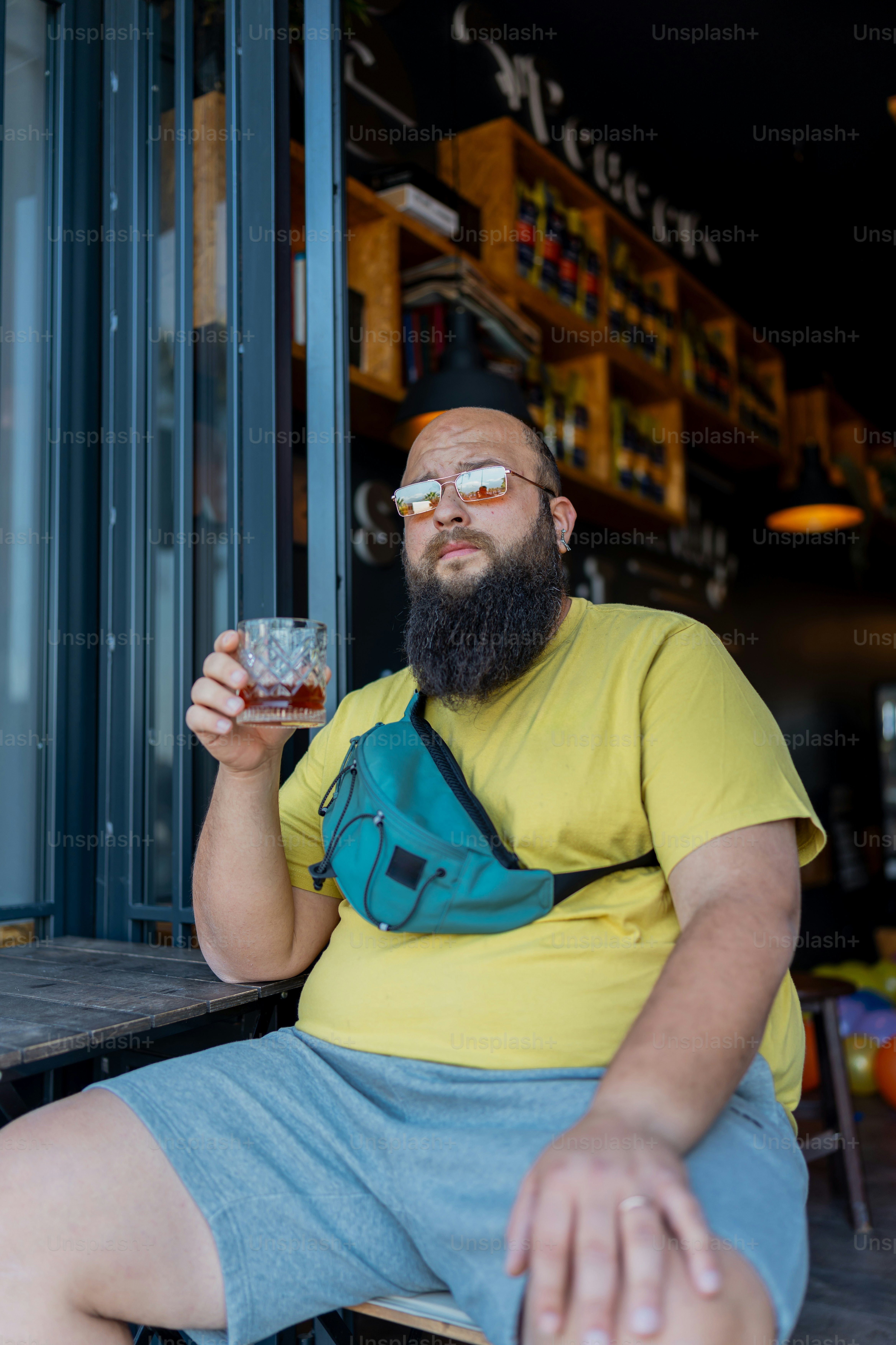 a man sitting at a table with a drink in his hand