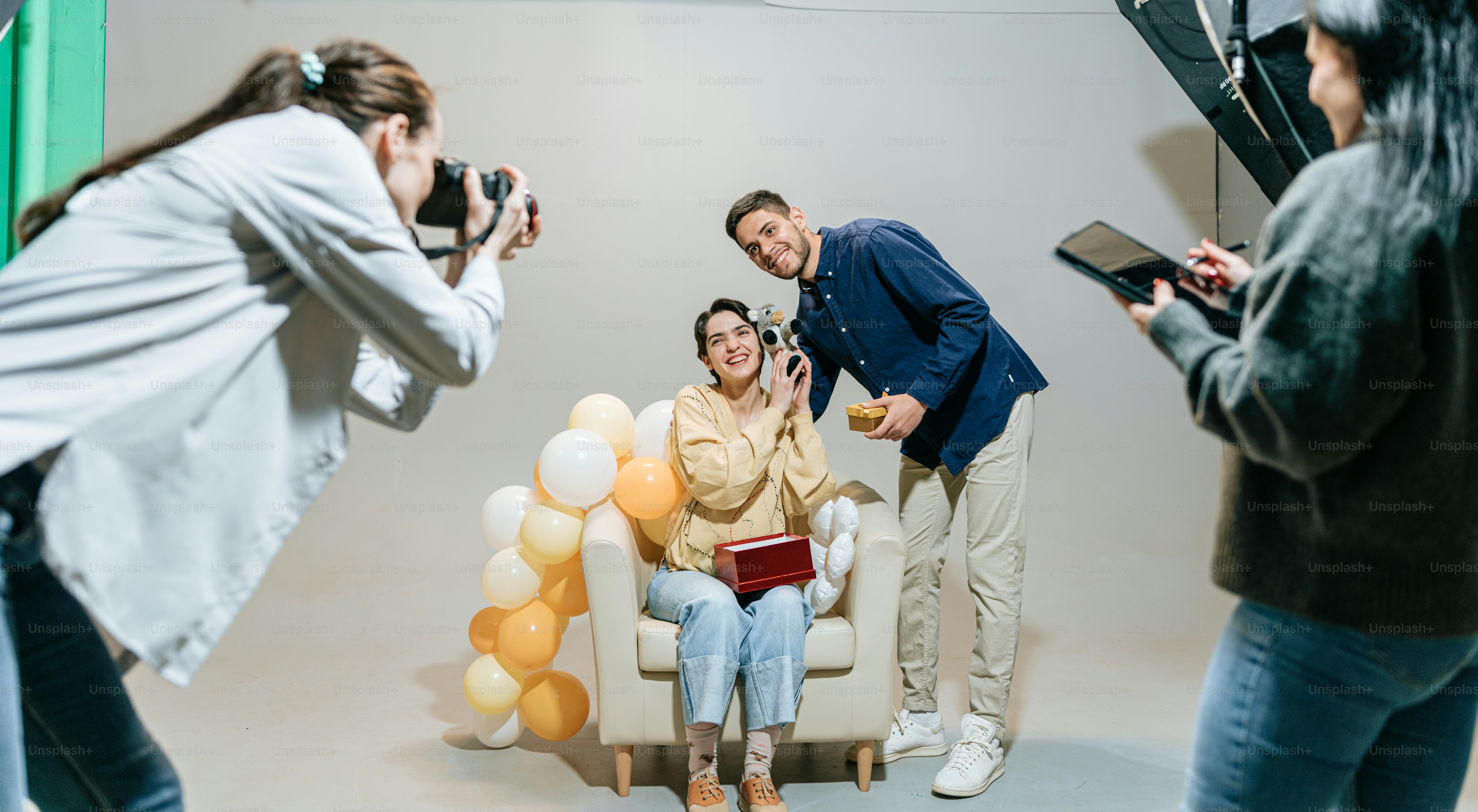 a man taking a picture of a woman sitting in a chair