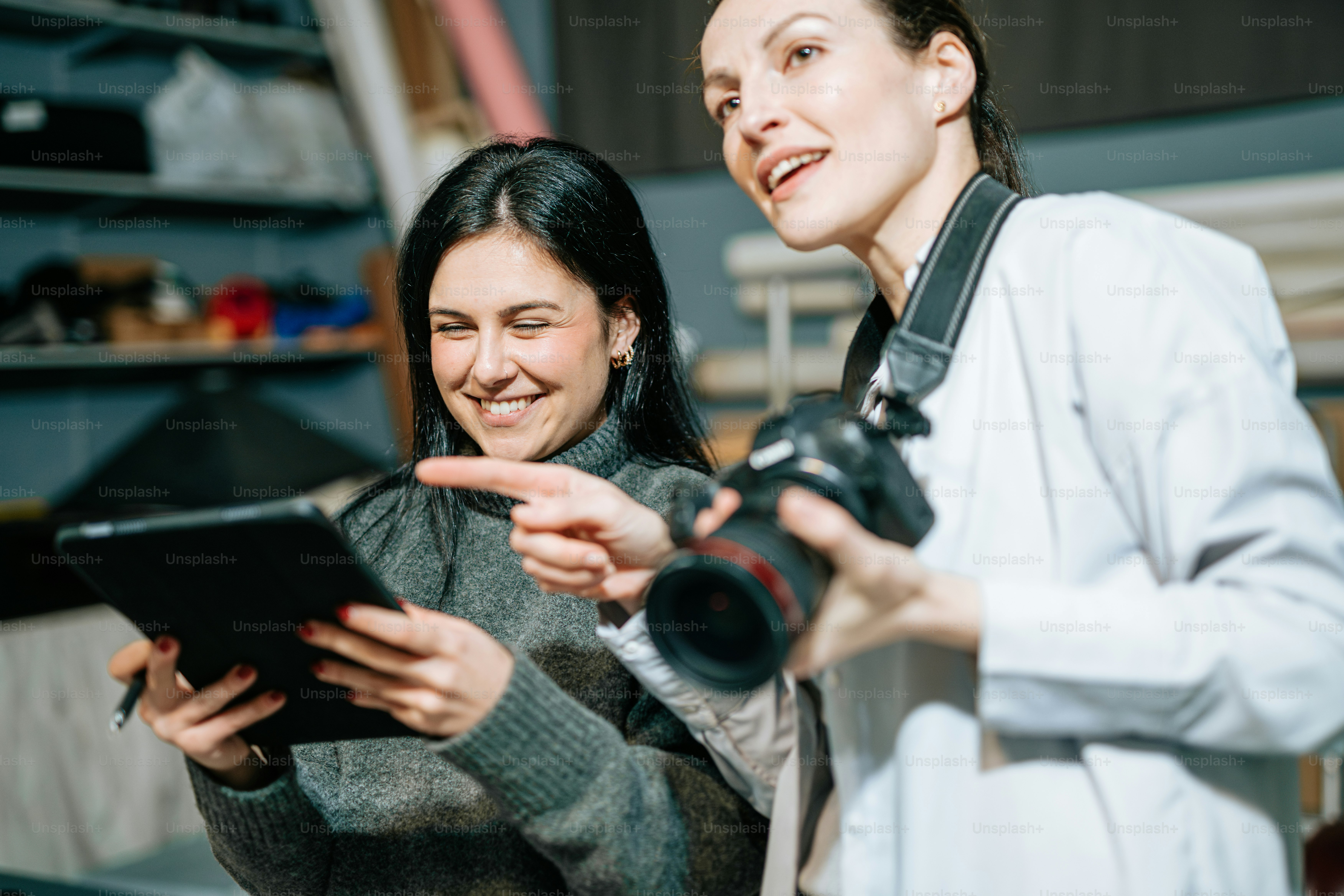 Due donne in piedi l'una accanto all'altra che guardano una tavoletta