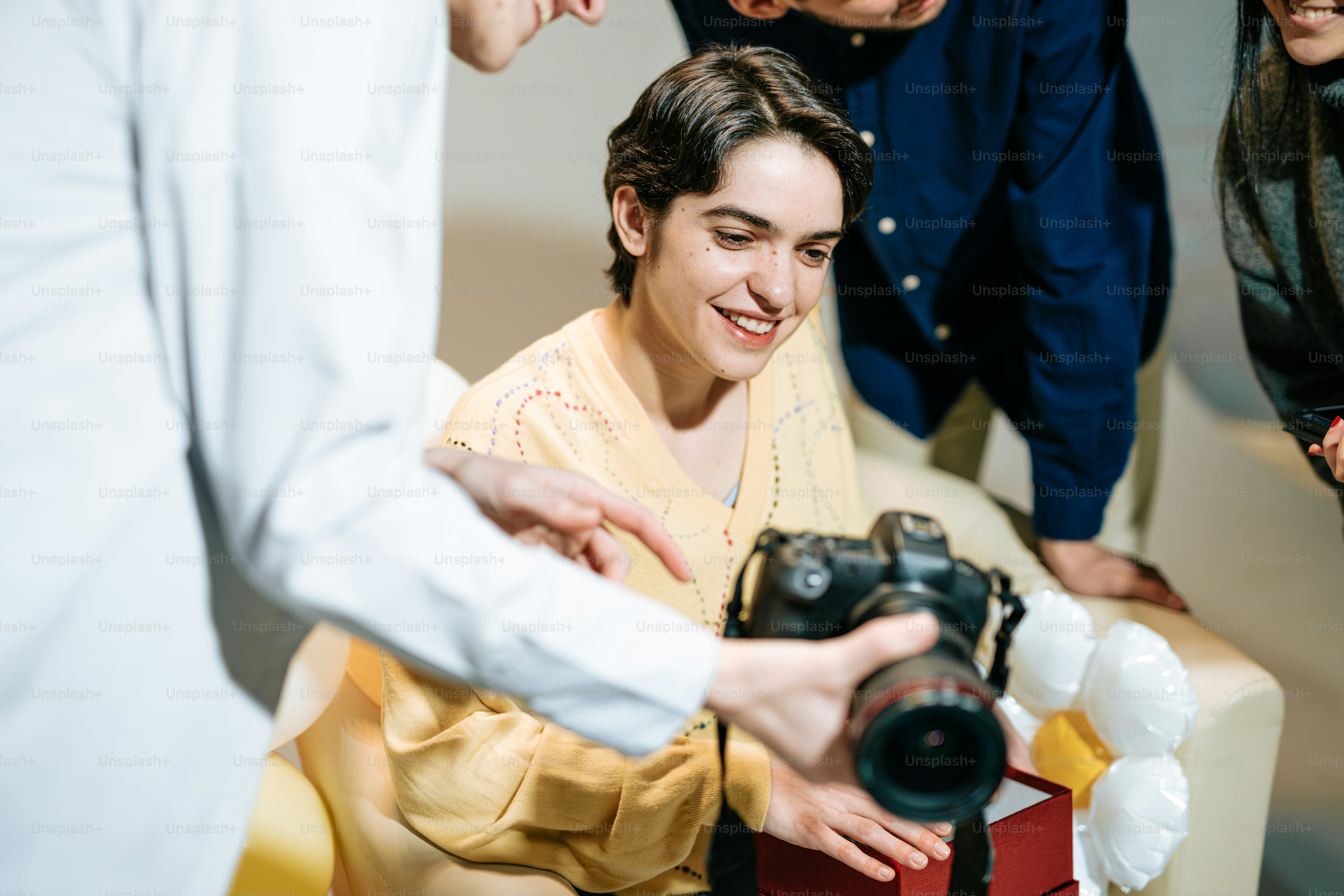a woman holding a camera in front of a group of people