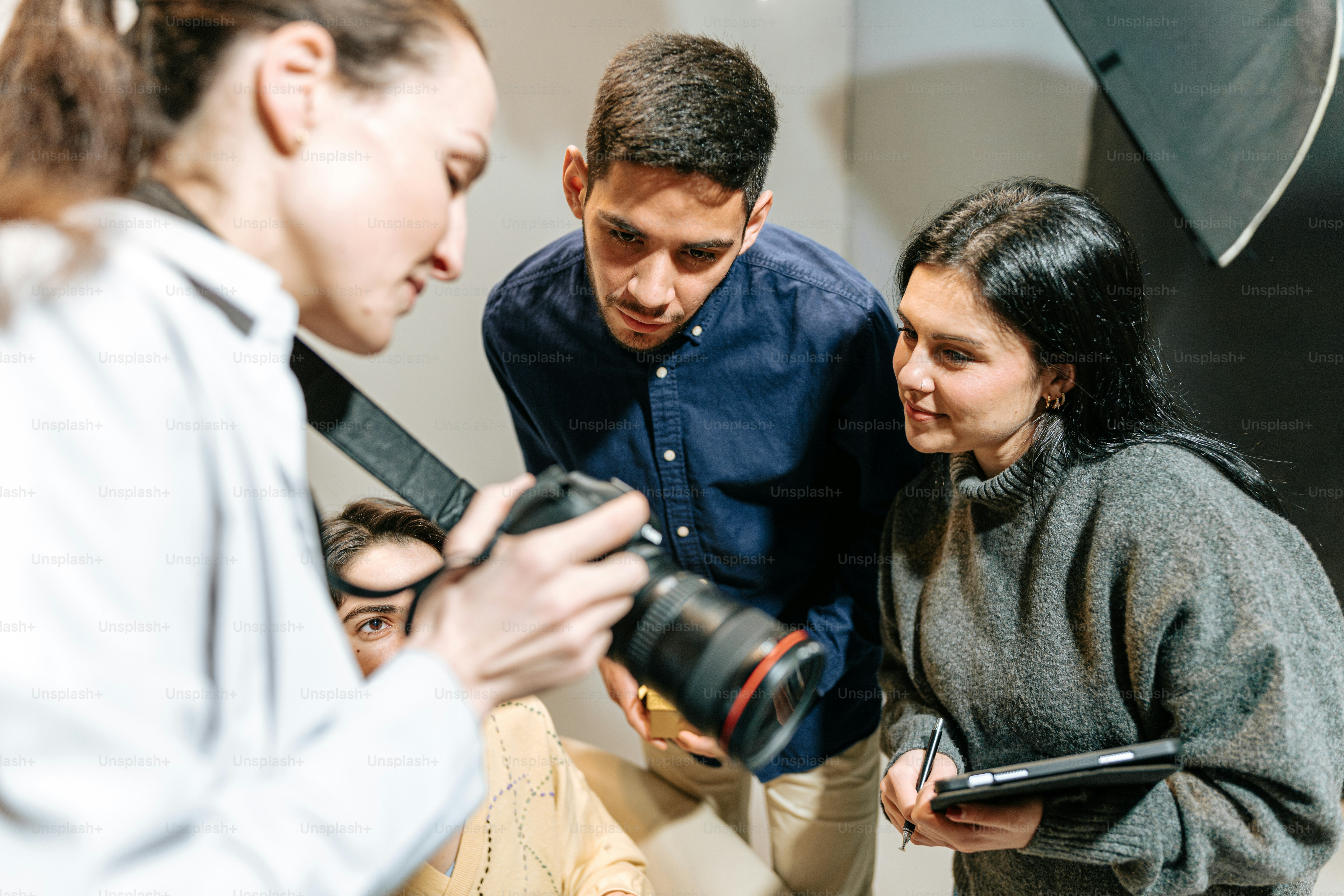 A group of people standing around a camera photo – Model Image on Unsplash