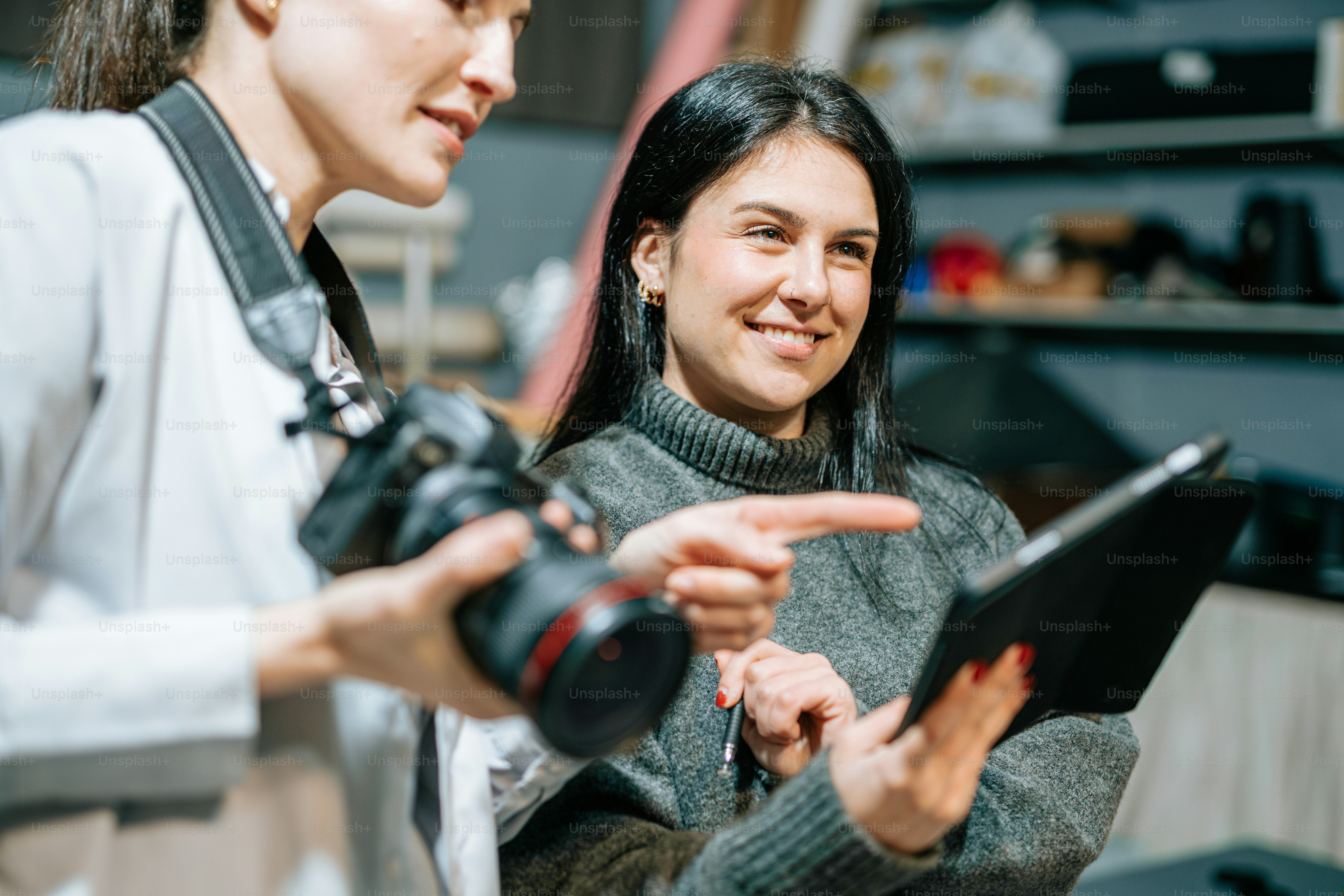 two women are looking at something on a tablet