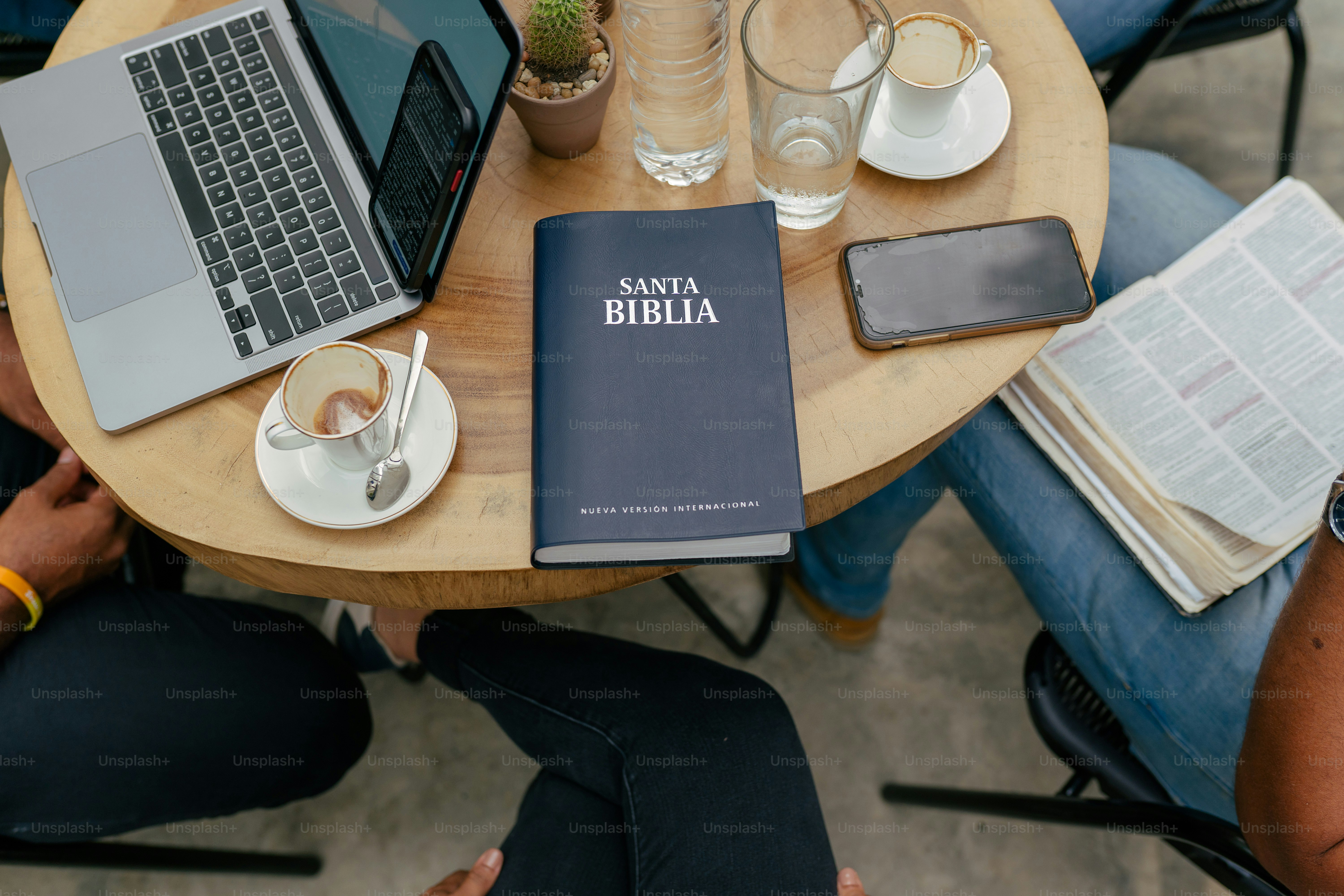 a person sitting at a table with a book and a laptop